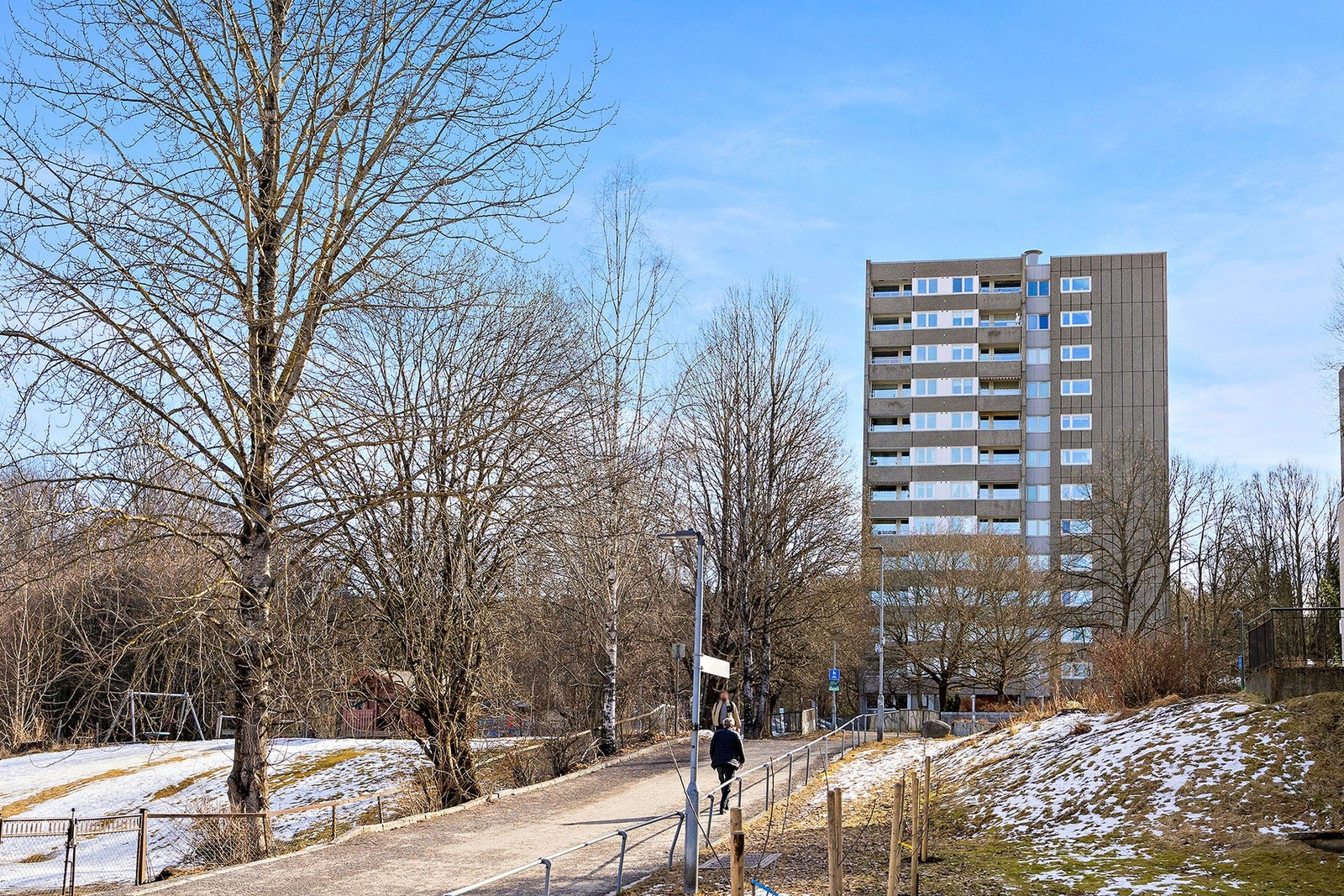Leiligheten er omringet av store plenarealer med løv og vintergrønne trær som innbyr til bruk av området. Galleribilde