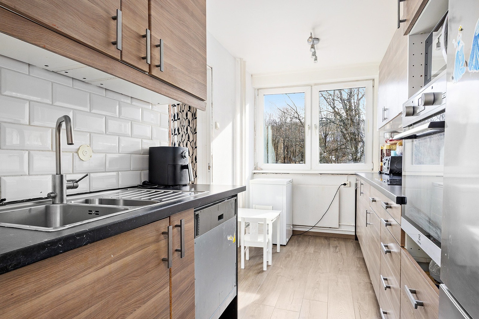 Romslig kjøkken med eldre, men solid kjøkkeninnredning og profilerte fronter. Galleribilde