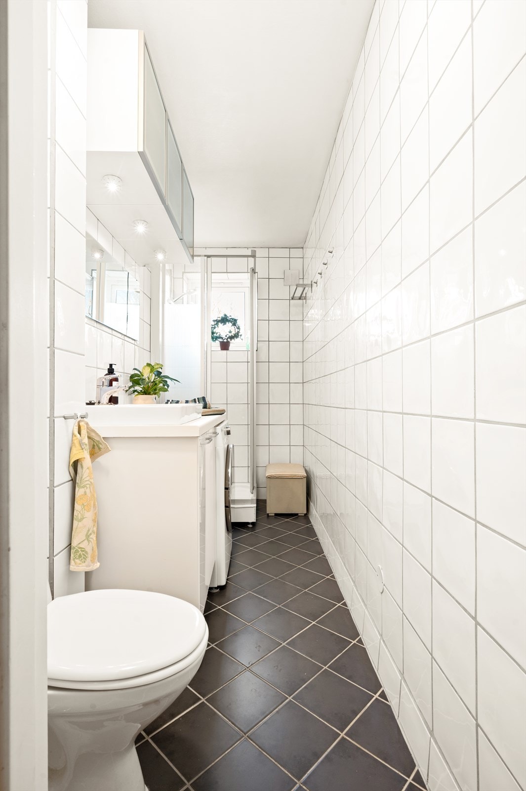 Videre har badet dusjkabinett med skyvedører av glass og metall og gulvstående toalett. Galleribilde