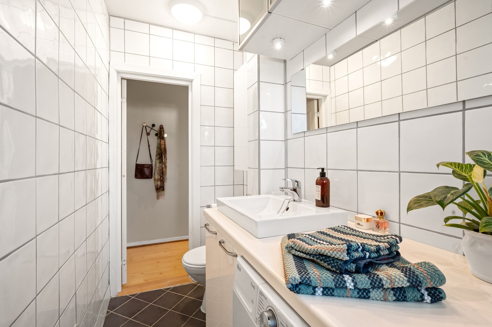 Over servanten er det både speil og vegghengte skap, samt belsyning. Under benkeplaten er det opplegg for vaskemaskin. Det er også et praktisk vegghengt skap over toalettet. Galleribilde