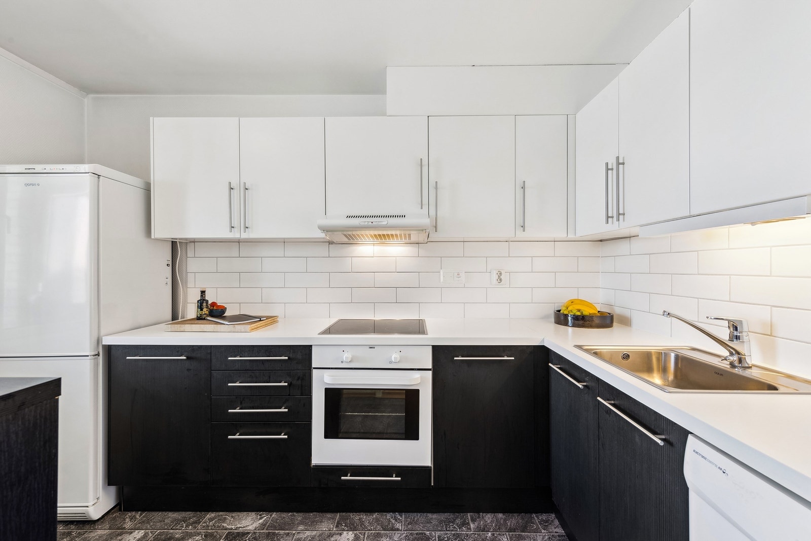 Lyst og stilfullt kjøkken med integrert stekeovn og koketopp. Galleribilde