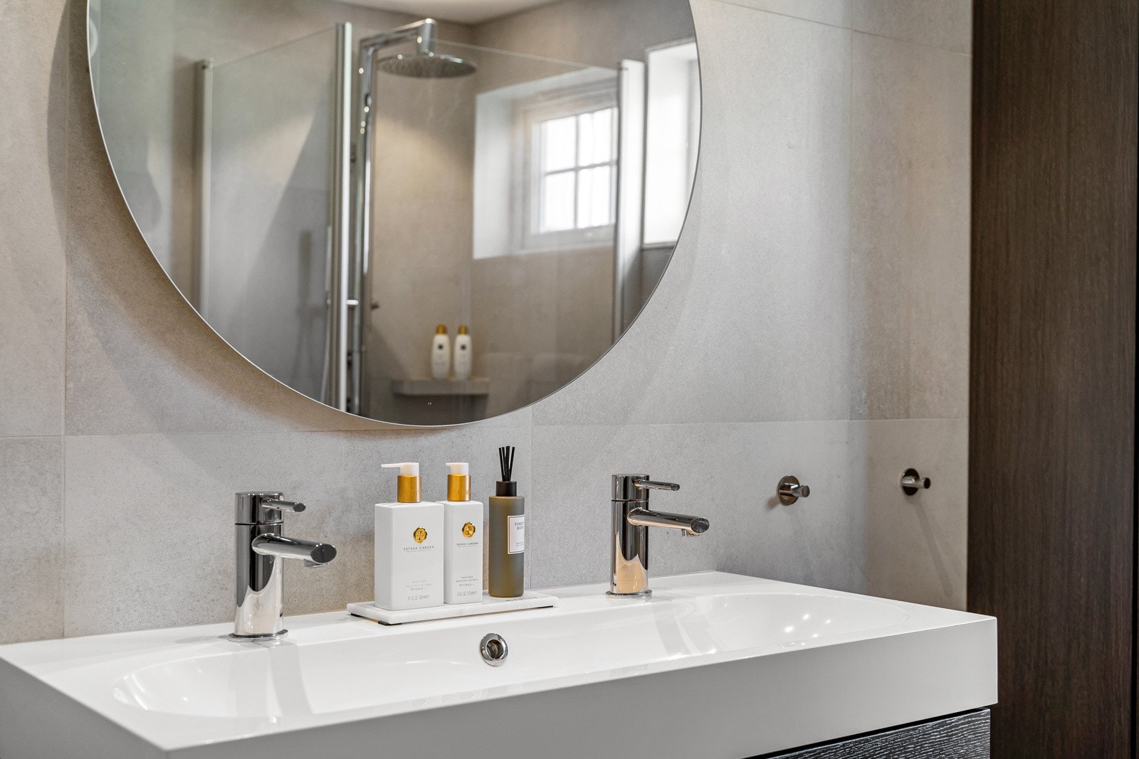 Badet er utsyrt med servantinnredning, vegghengt toalett, dusjhjørne med glassdører og opplegg for vaskemaskin. Galleribilde