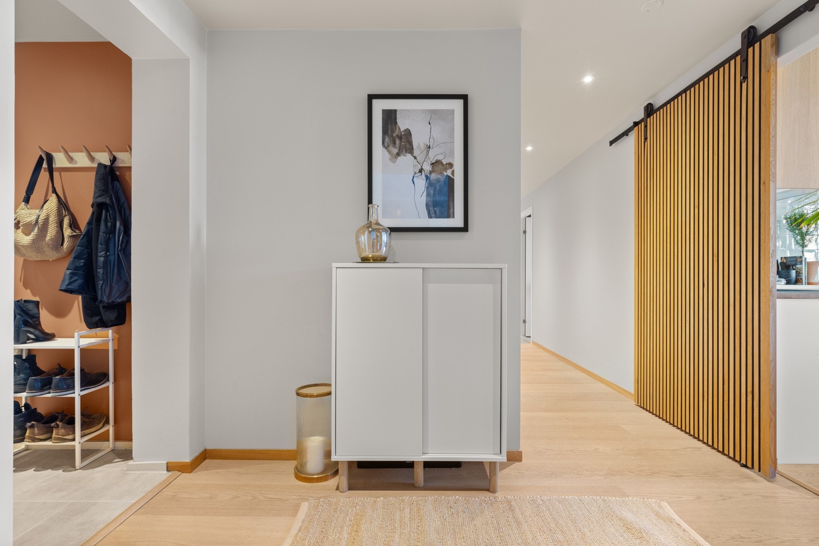 Velkommen inn! Romslig entré og gang med plass til å henge fra seg yttertøy, samt god plass til møblement for oppbevaring av klær og sko. Behagelig varme i flislagt gulv. Galleribilde