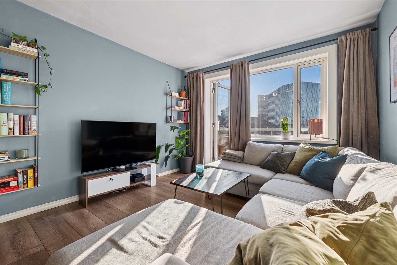 Boligens stue fremstår som lys og romslig, her får du rikelig med lysinnslipp som bidrar til en hyggelig atomsfære Galleribilde