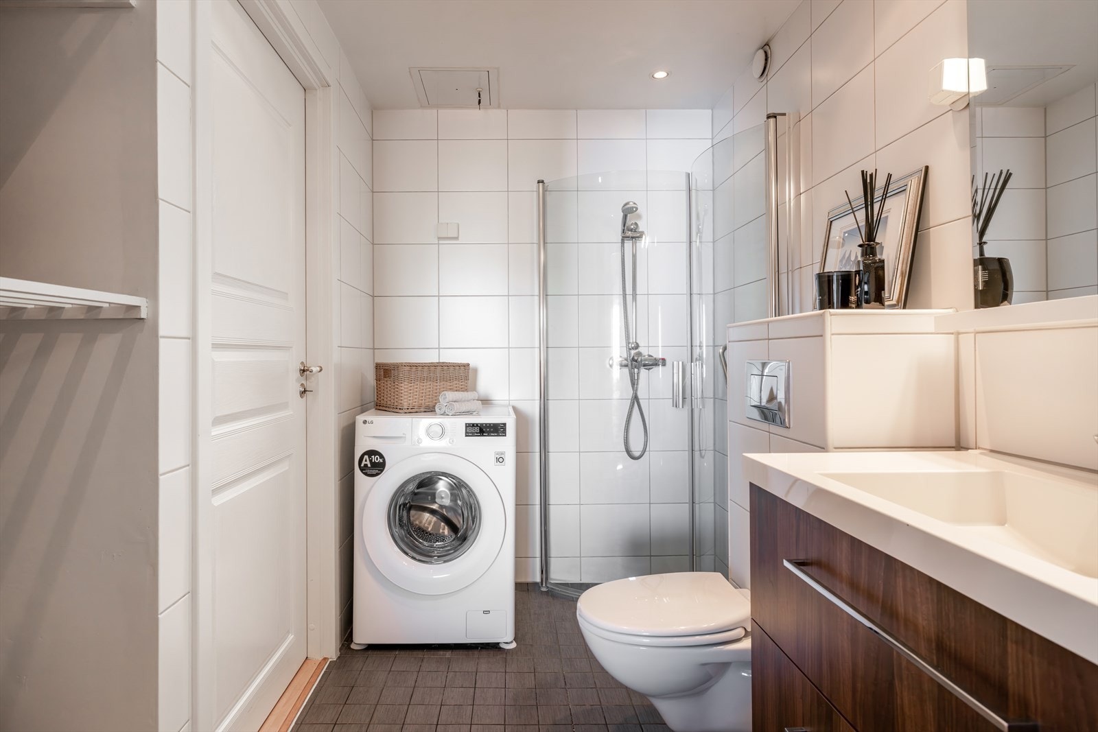 Badet inneholder veggmontert wc, dusjhjørne, servant med ettgreps blandebatteri i innredning og god skap- og oppbevaringsplass. Galleribilde