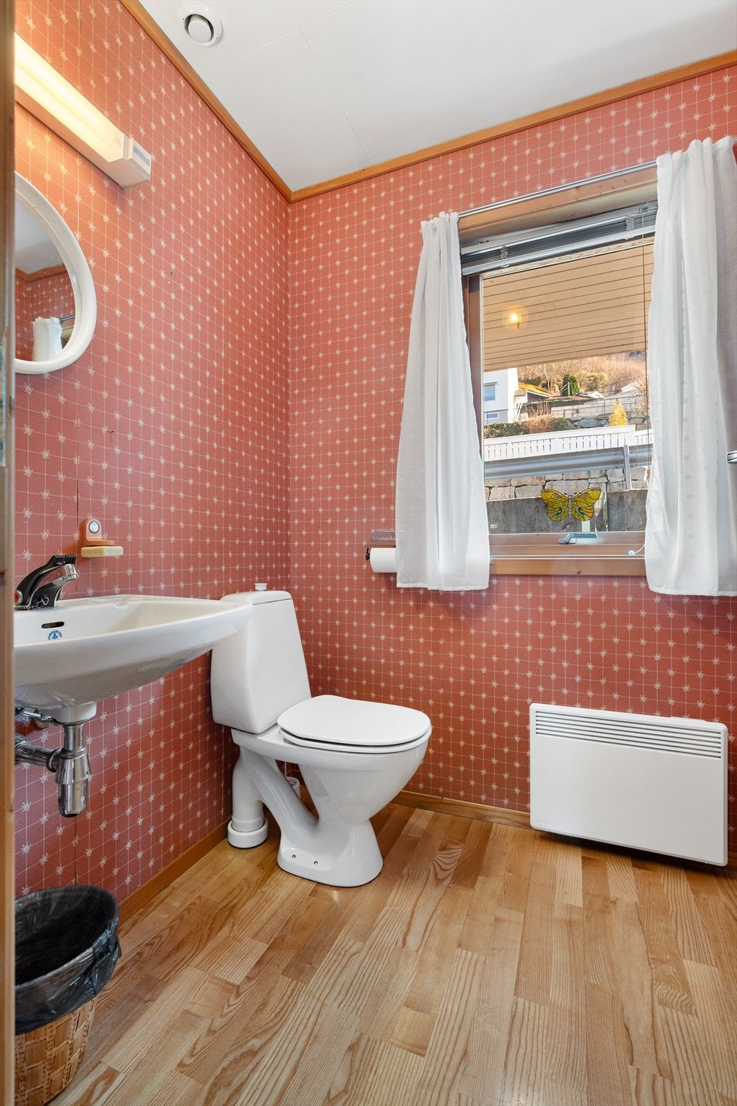 Toalettrommet har overflater med parkett på gulv, tapetserte vegger og malte takflater. Galleribilde