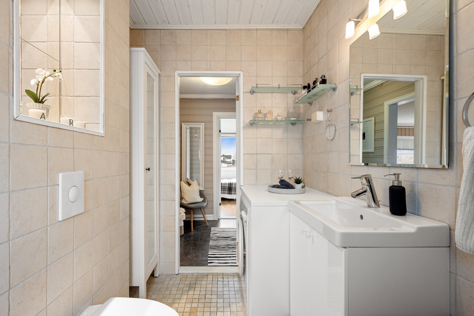 Lyst og fint flislagt bad som ligger rett ved entreen. Galleribilde