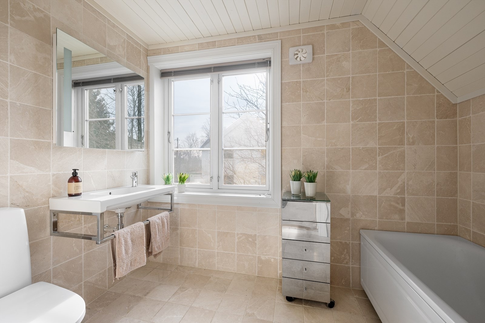 Innenfor dusjrommet er flott bad fra 2000-tallet - det er innredet med servant, toalett og badekar Galleribilde