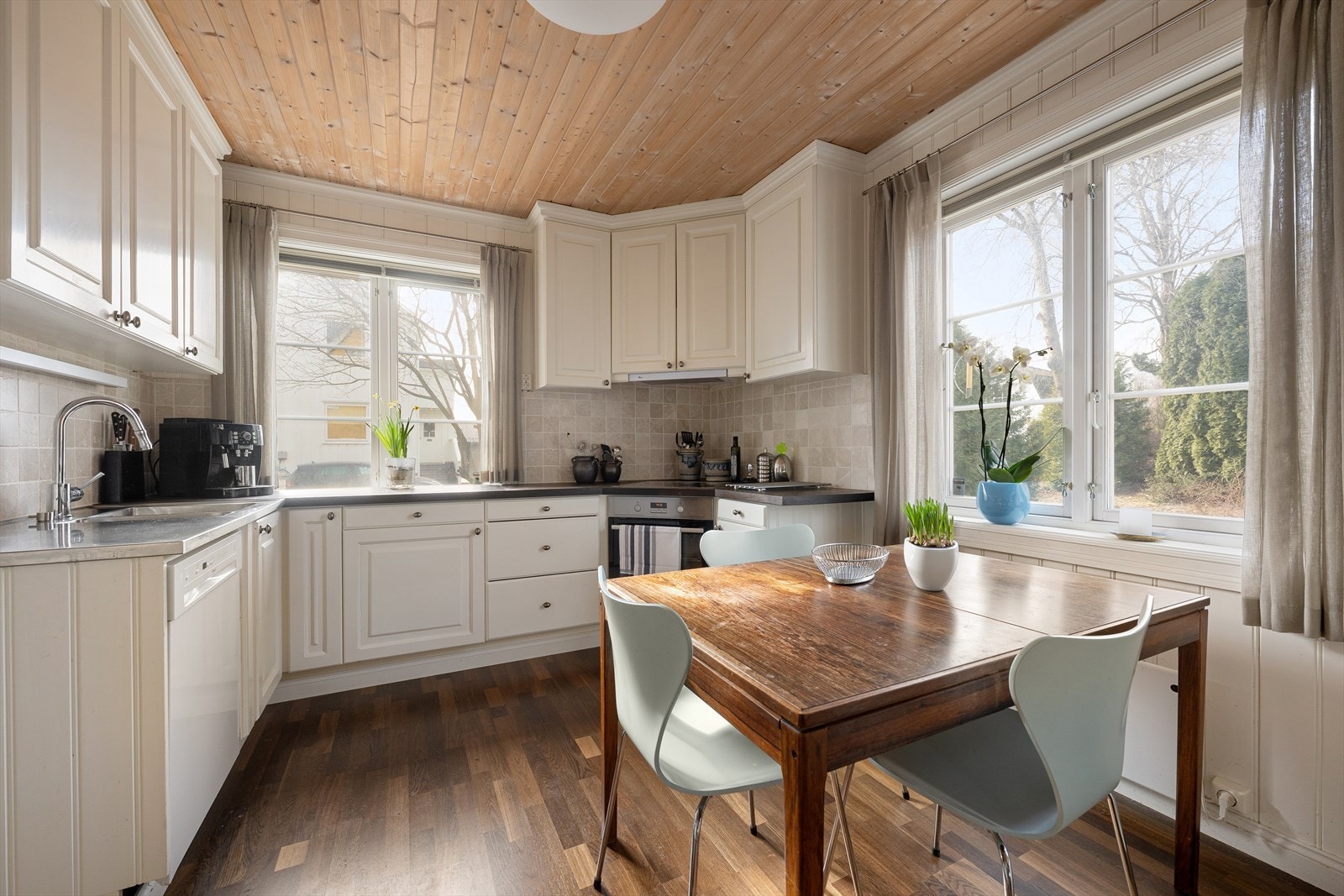 Kjøkkenet er innredet med profilerte fronter, benkeplate i tre, benkebeslag av stål med nedfelt vask og integrerte hvitevarer som består platetopp, stekeovn og mikrobølgeovn Galleribilde