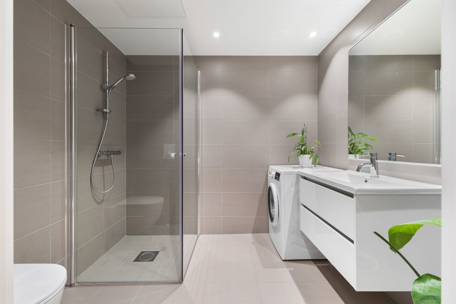 Delikat flislagt bad med flislagte gulv og vegger. Varme i gulv. Dimbare LED downlights i himling Galleribilde