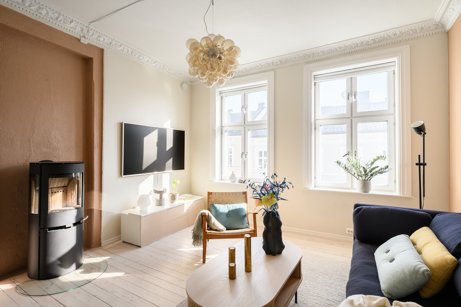 Lyst og luftig: Store vinduer gjør at rommet bader i dagslys. En moderne peisovn gir ekstra hygge. Galleribilde