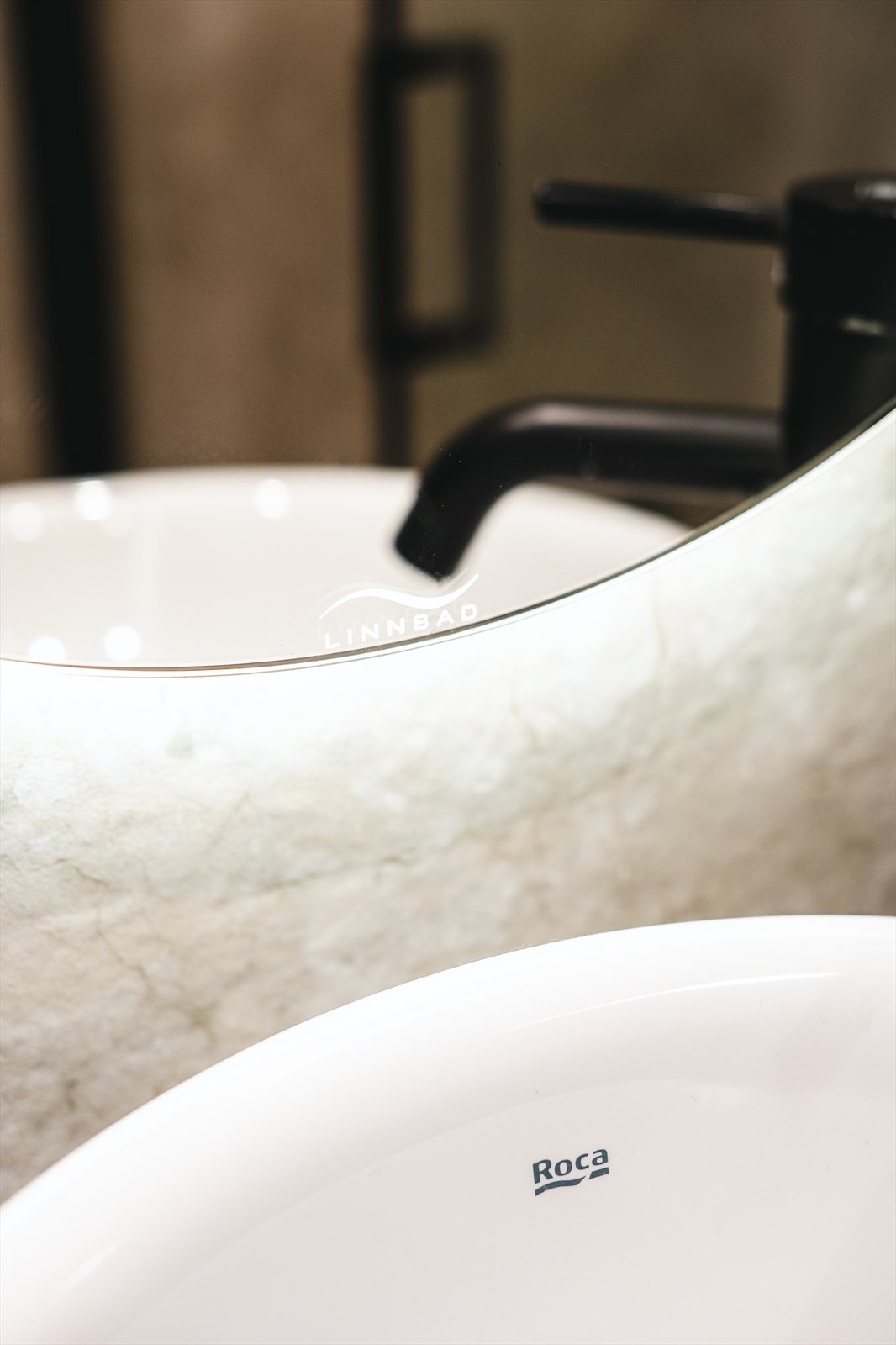 Badet er utstyrt med vegghengt toalett, dusjnisje med regndusj, servantinnredning og speil med lys. De store flisene gir et eksklusivt uttrykk, med moderne stilvalg. Galleribilde