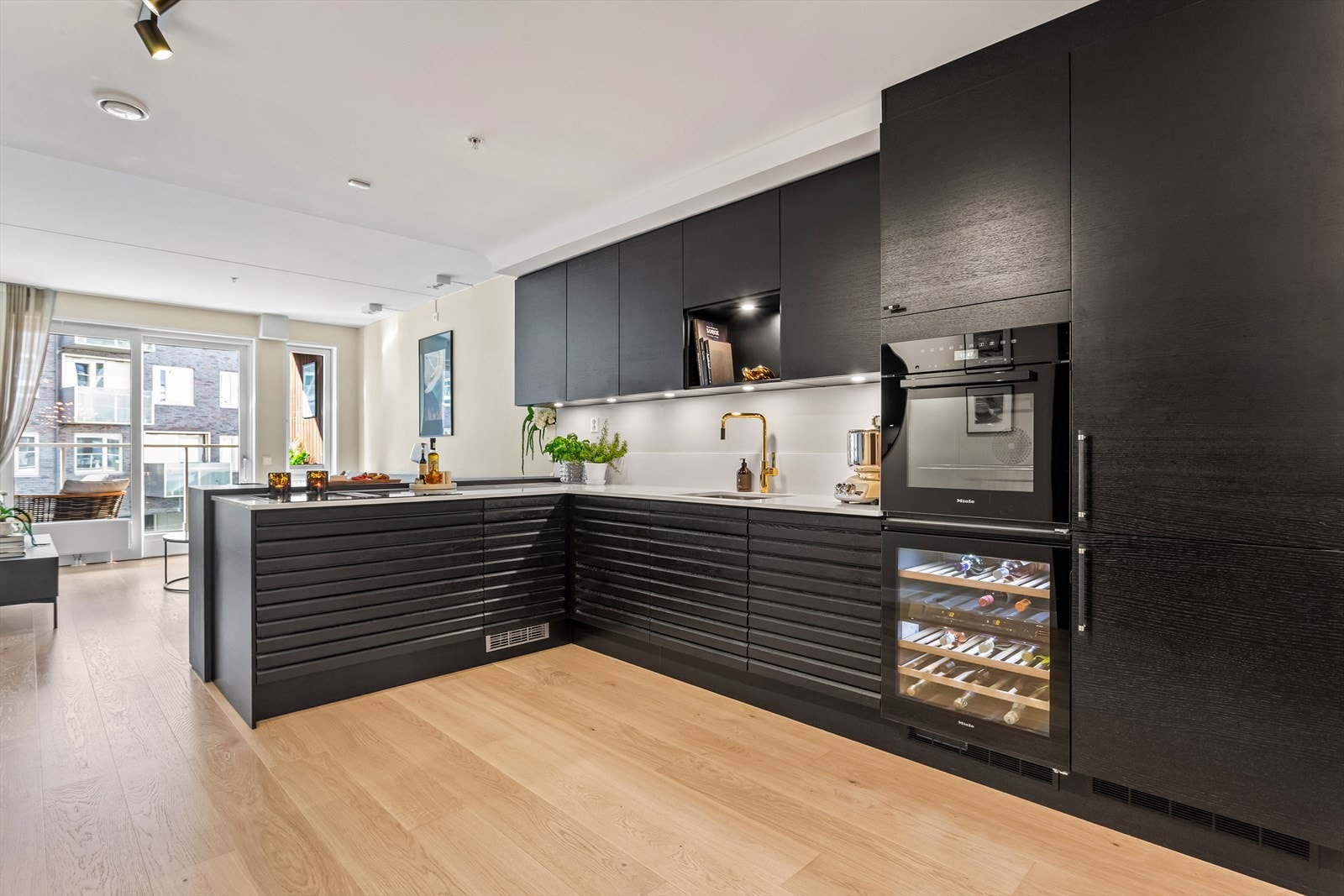 Nytt HTH-kjøkken fra 2021 med sorte fronter med lekre detaljer som corian benkeplate og fullintegrerte hvitevarer Galleribilde