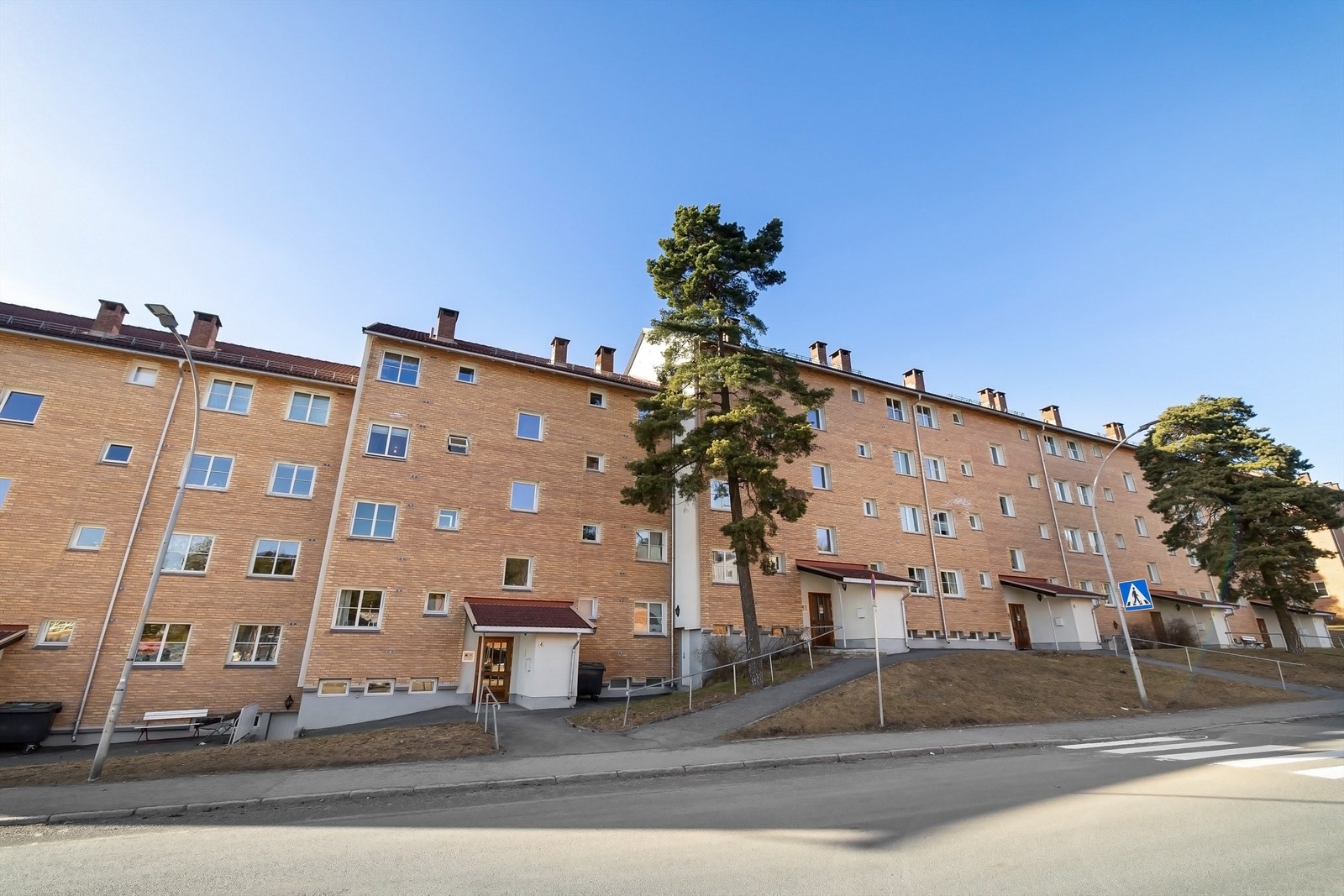 Fasaden sett fra inngangsparti - her ser du hvor høyt oppe første etasjen faktisk er! Galleribilde