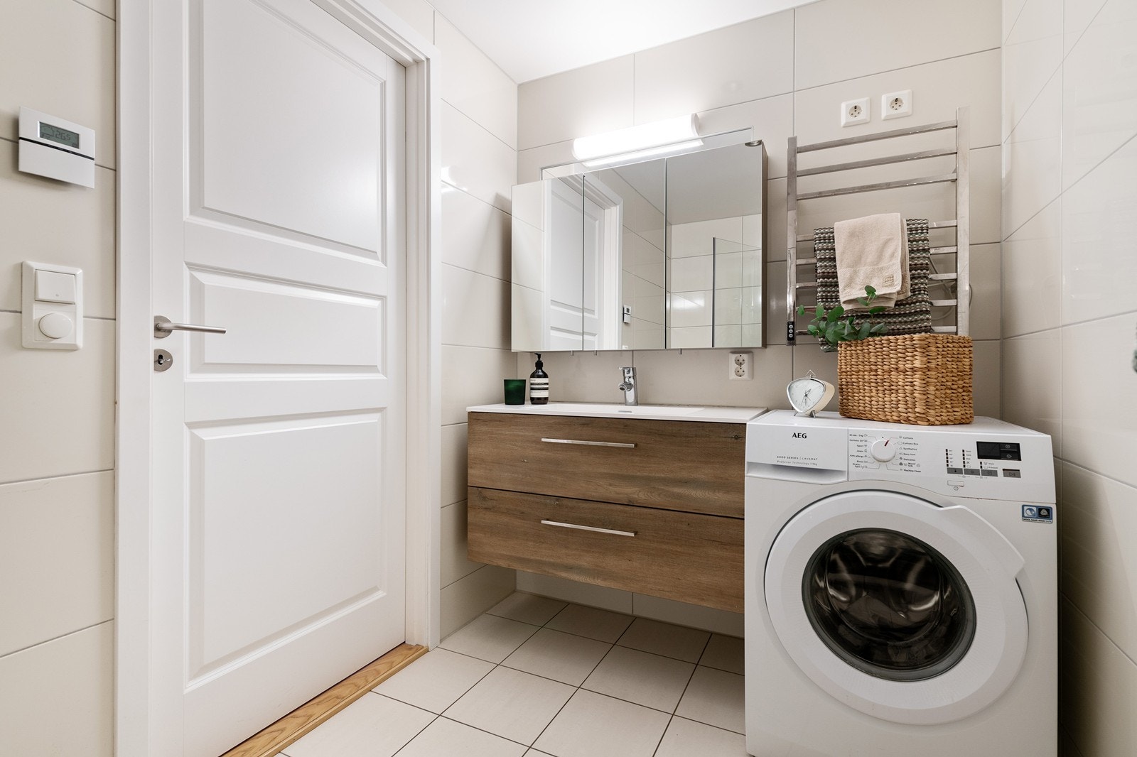 Baderommet er delikat og med nøytrale fliser på både gulv og vegger Galleribilde