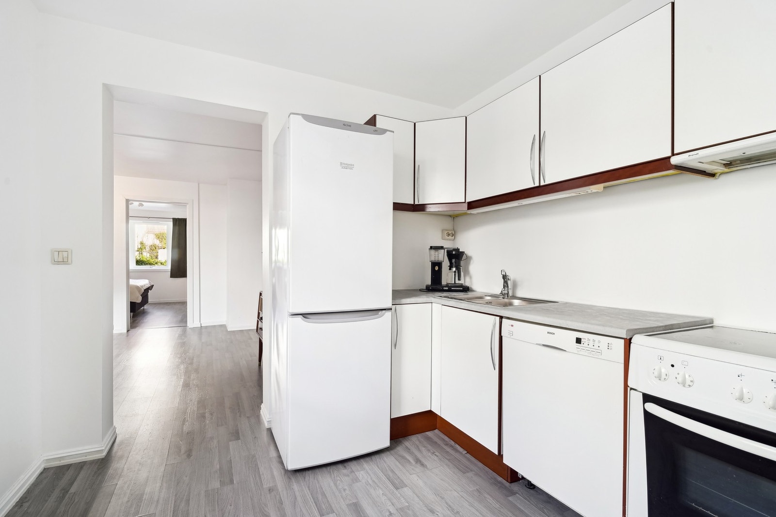 Kjøkkenet har innredning med hvite glatte fronter og foliert benkeplate i laminat. Galleribilde