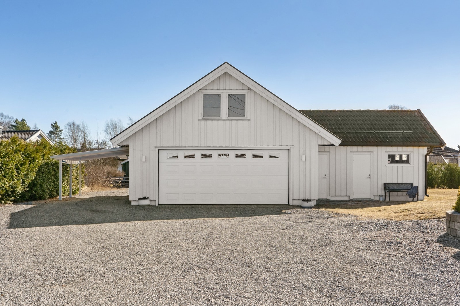 Romslig isolert dobbelgarasje med tilbygg og loft. Garasjen har også carport og elbillader. Galleribilde