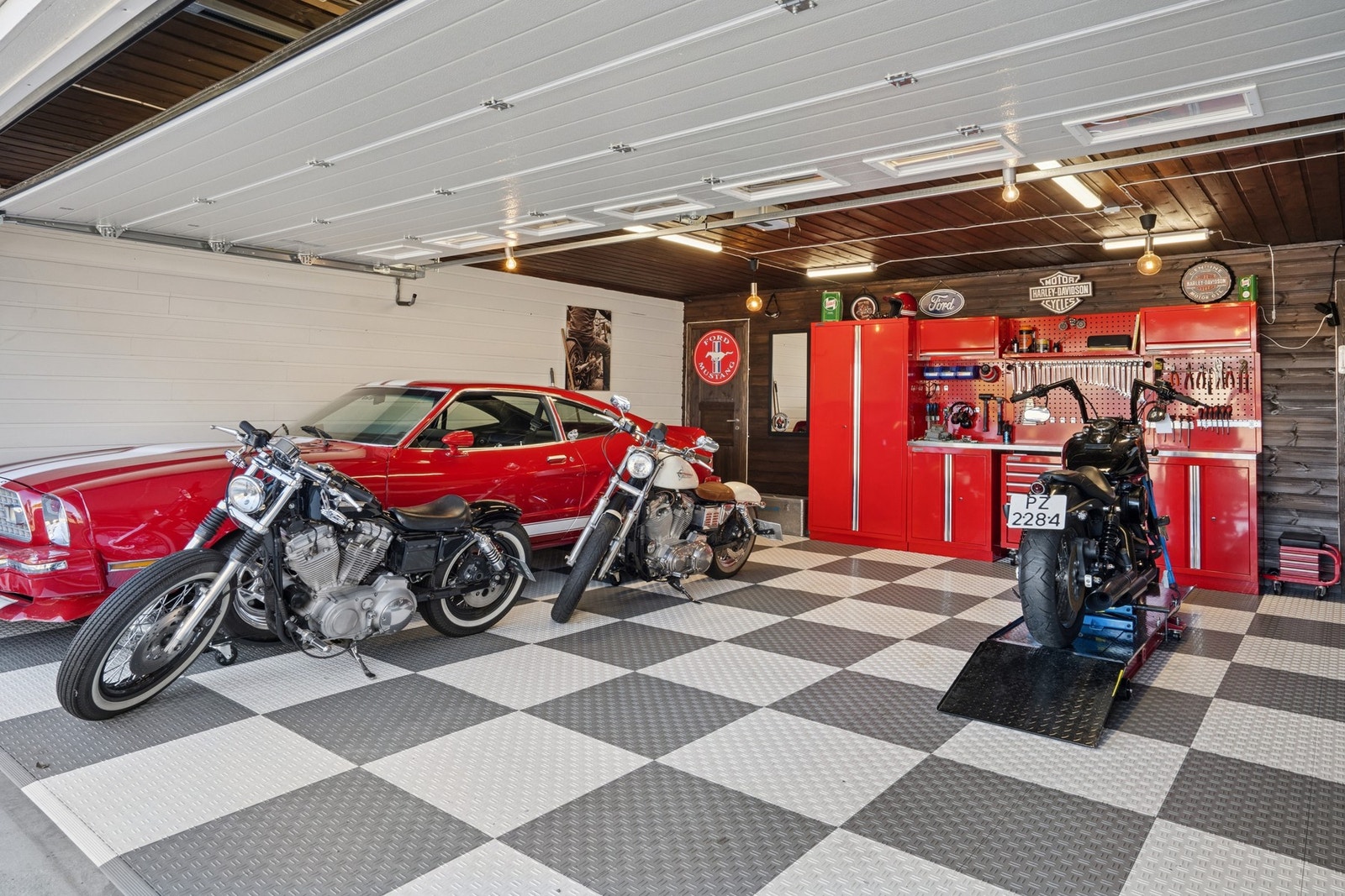 Garasjen er godt utstyrt med elektrisk garasjeport. (Garasjeinnredning medfølger ikke) Galleribilde