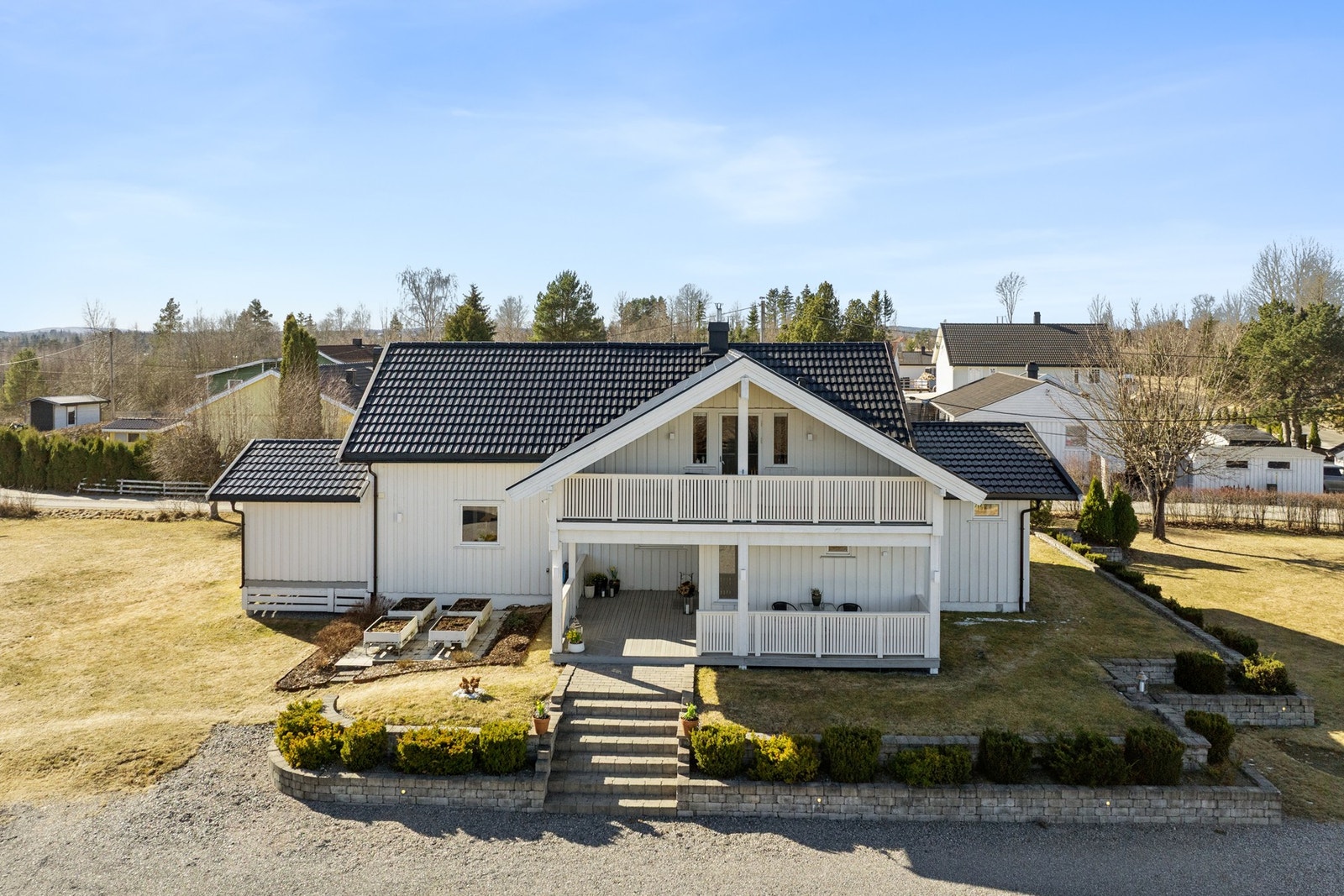 Tomten er pent opparbeidet med steinlagt inngangsparti, plen og diverse planter og busker. Galleribilde