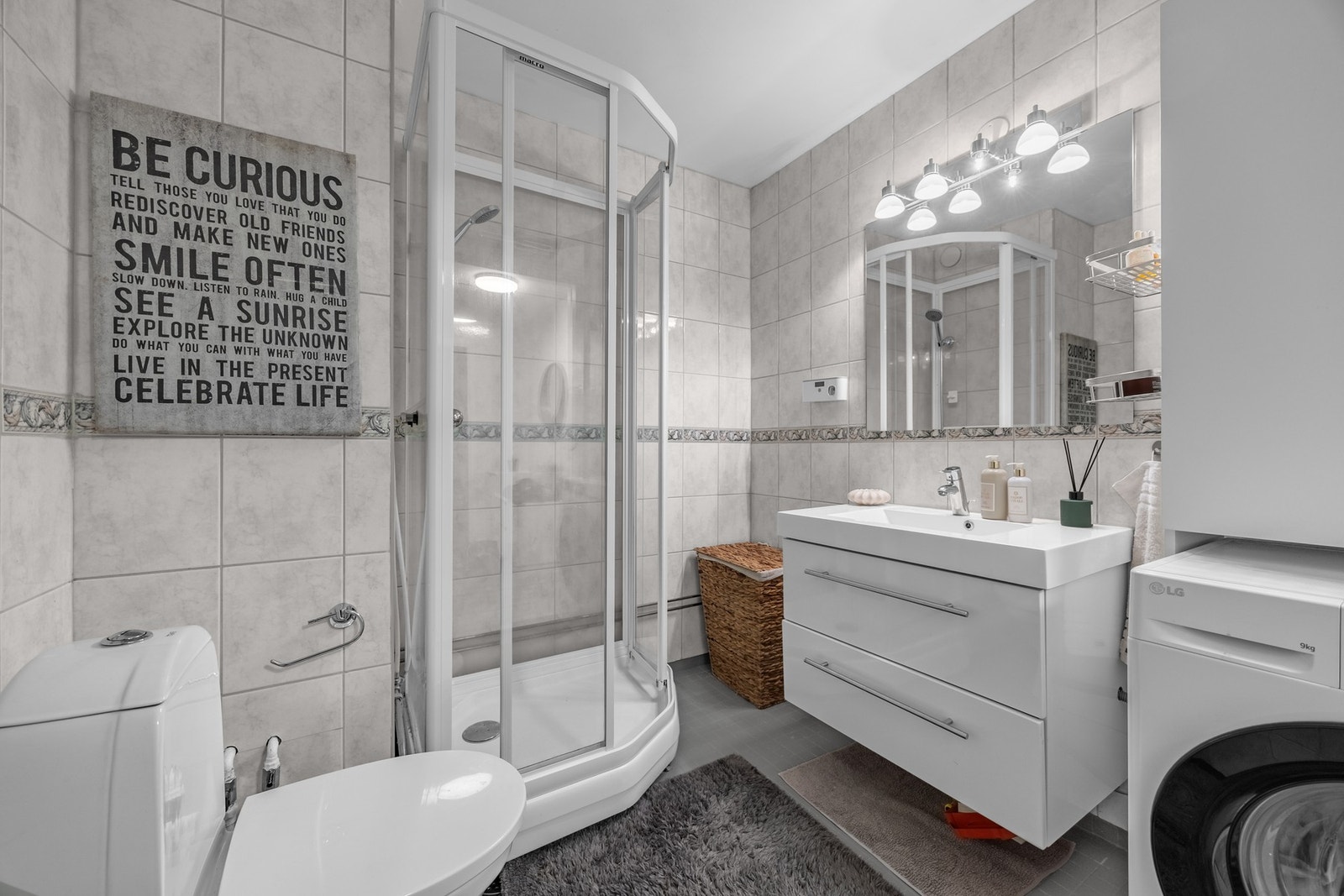 Badet består av gulvmontert klosett, servantskap med glatte fronter, dusjkabinett og opplegg for oppvaskmaskin. Galleribilde