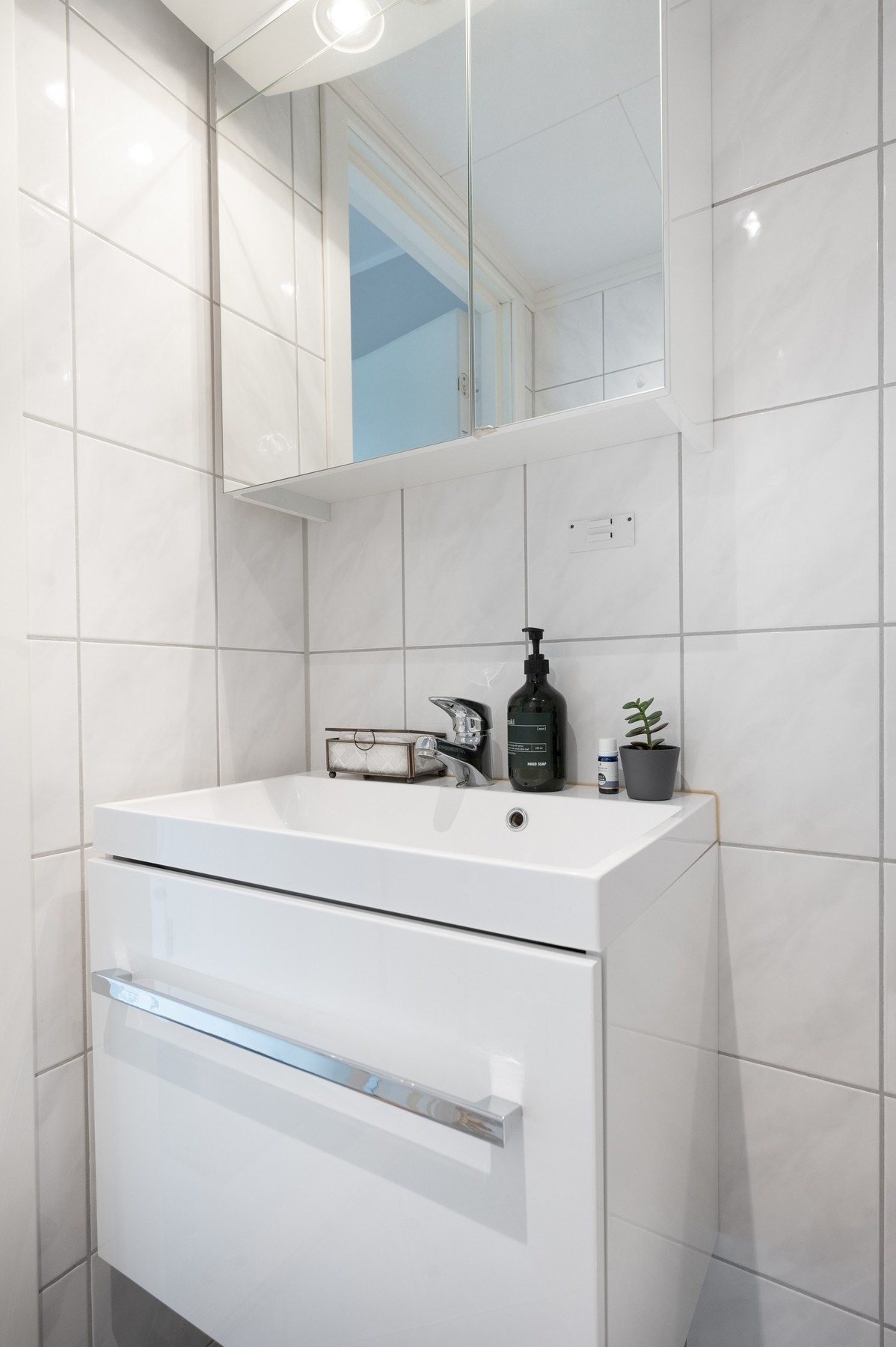 Badet inneholder toalett, dusjkabinett og vegghengt servantinnredning med speilskap. Galleribilde