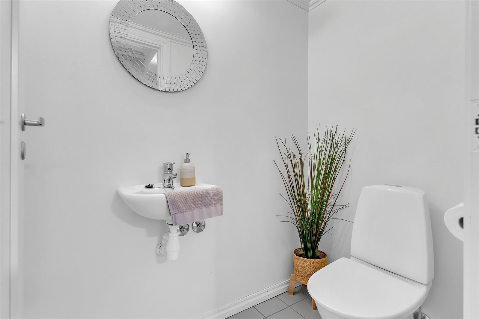 Leiligheten har også et meget praktisk toalettrom, som er innredet med fliser på gulv med underliggende varme, gulvstående toalett og servant. Galleribilde