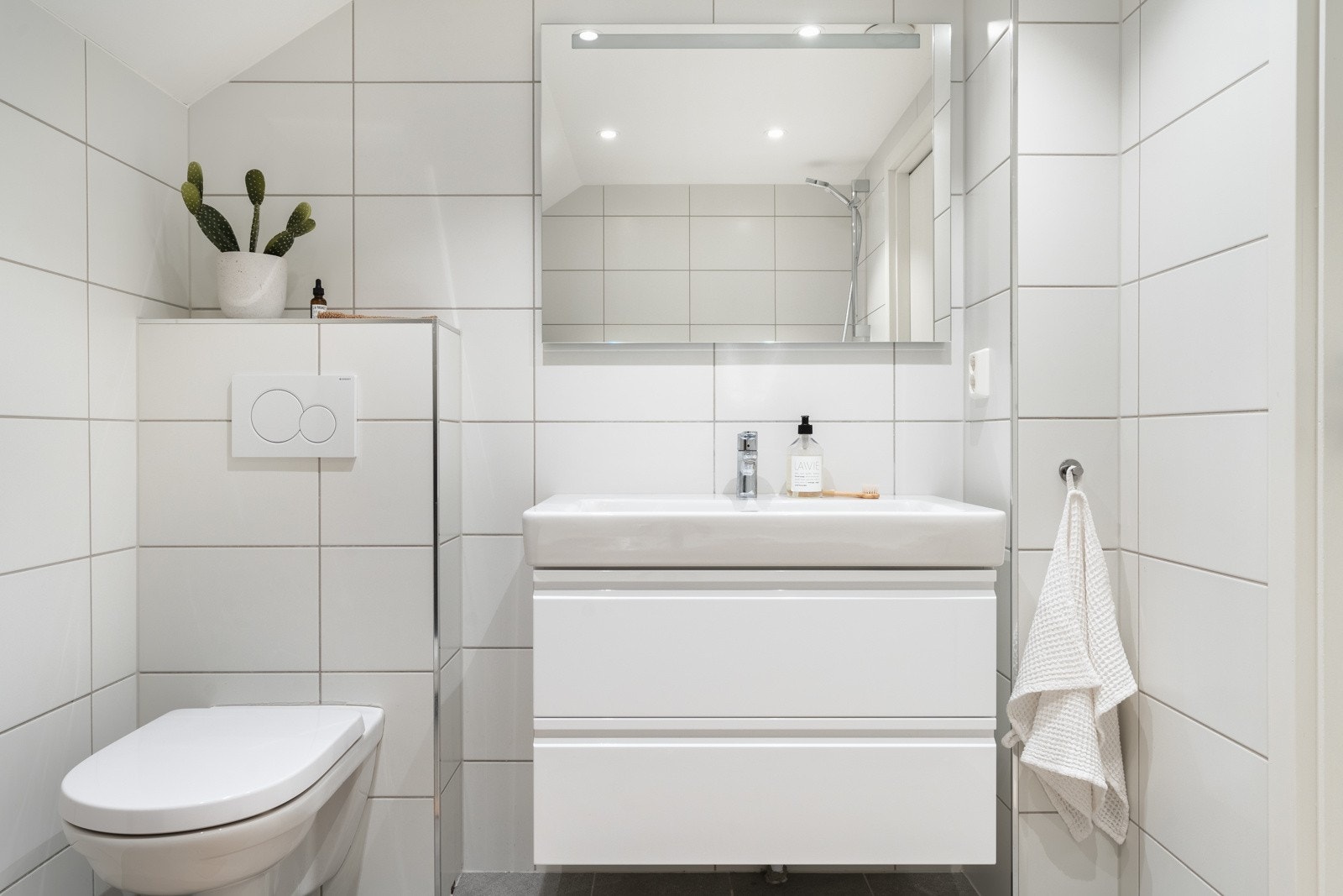 Badet er innredet med: Badekar m/dusj, vegghengt toalett og baderomsinnredning. Galleribilde