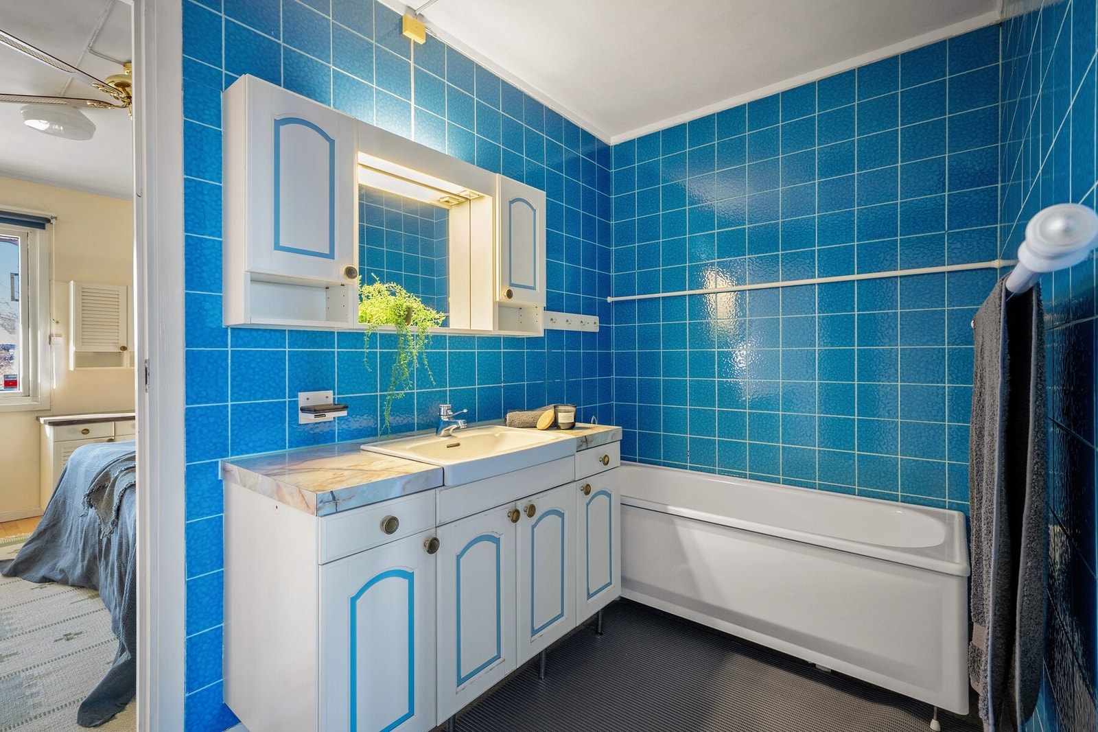 Hovedbadet i 1. etasje har flislagte vegger, gulvbelegg og et elegant frittstående badekar som innbyr til avslappende stunder. Galleribilde