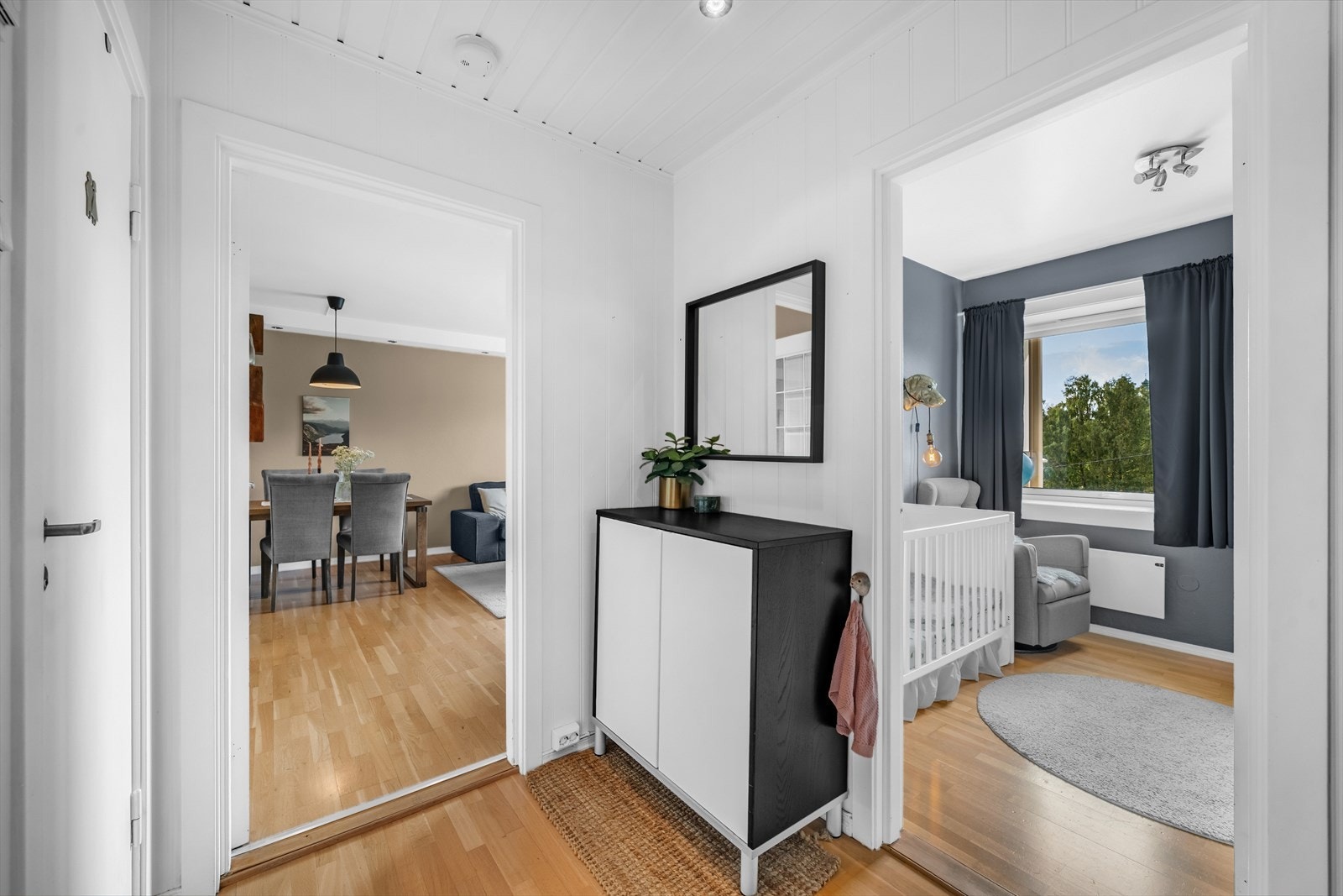 Her møter du en harmonisk kombinasjon av lyse vegger og naturlige tretoner i gulv og dør. Galleribilde