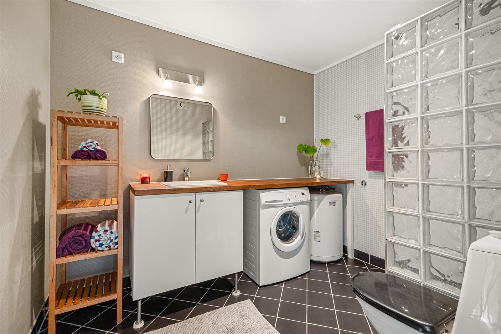 Badet har fliser på to av veggene, og på gulvet med varmekabler. Galleribilde