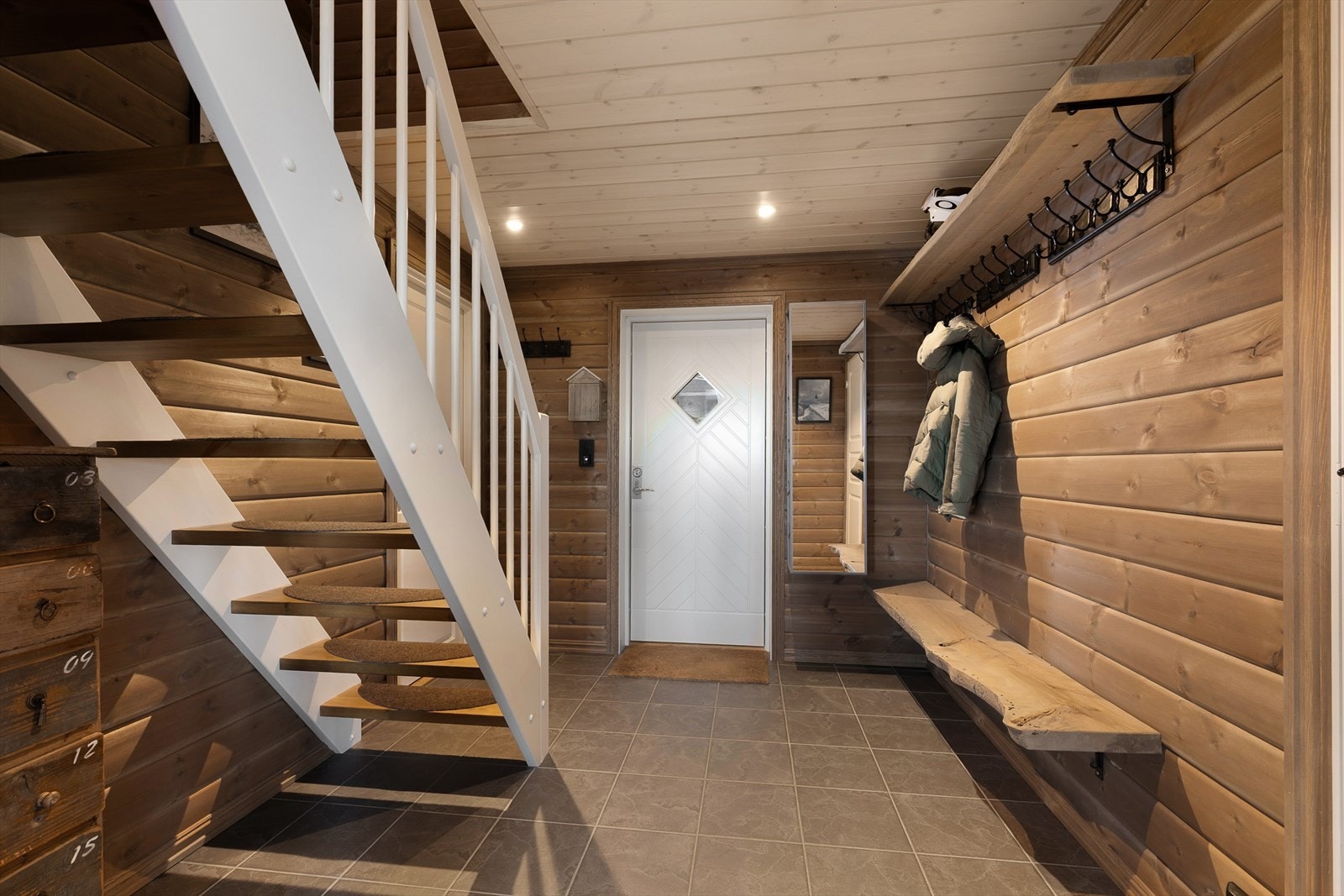 Entreen som ønsker deg velkommen inn, og har flislagt lekkert gulv og lun panel på vegger. Galleribilde