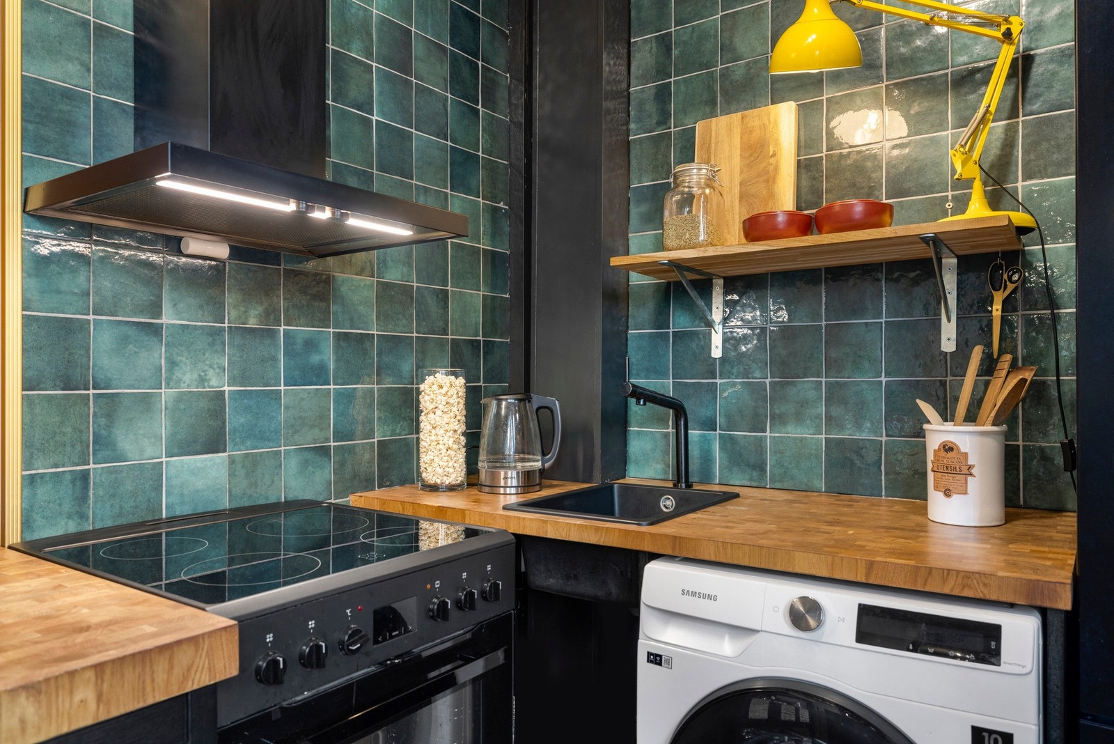 Flott innredning bestående av frittstående komfyr med steketopp, frittstående kjøleskap med fryser, nedfelt oppvasskkum i kompositt, vegghengt ventilator med kullfilter og det er opplegg for vaskemaskin. Galleribilde