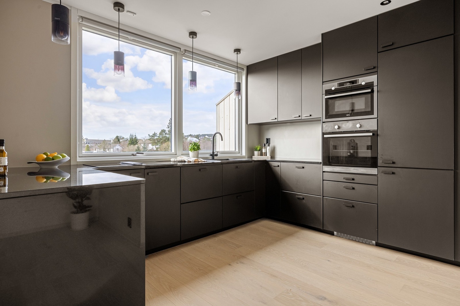 Kjøkkenet som ble pusset opp i 2021, har en lekker innredning fra Ikea med glatte sorte fronter og laminert benkeplate. Galleribilde