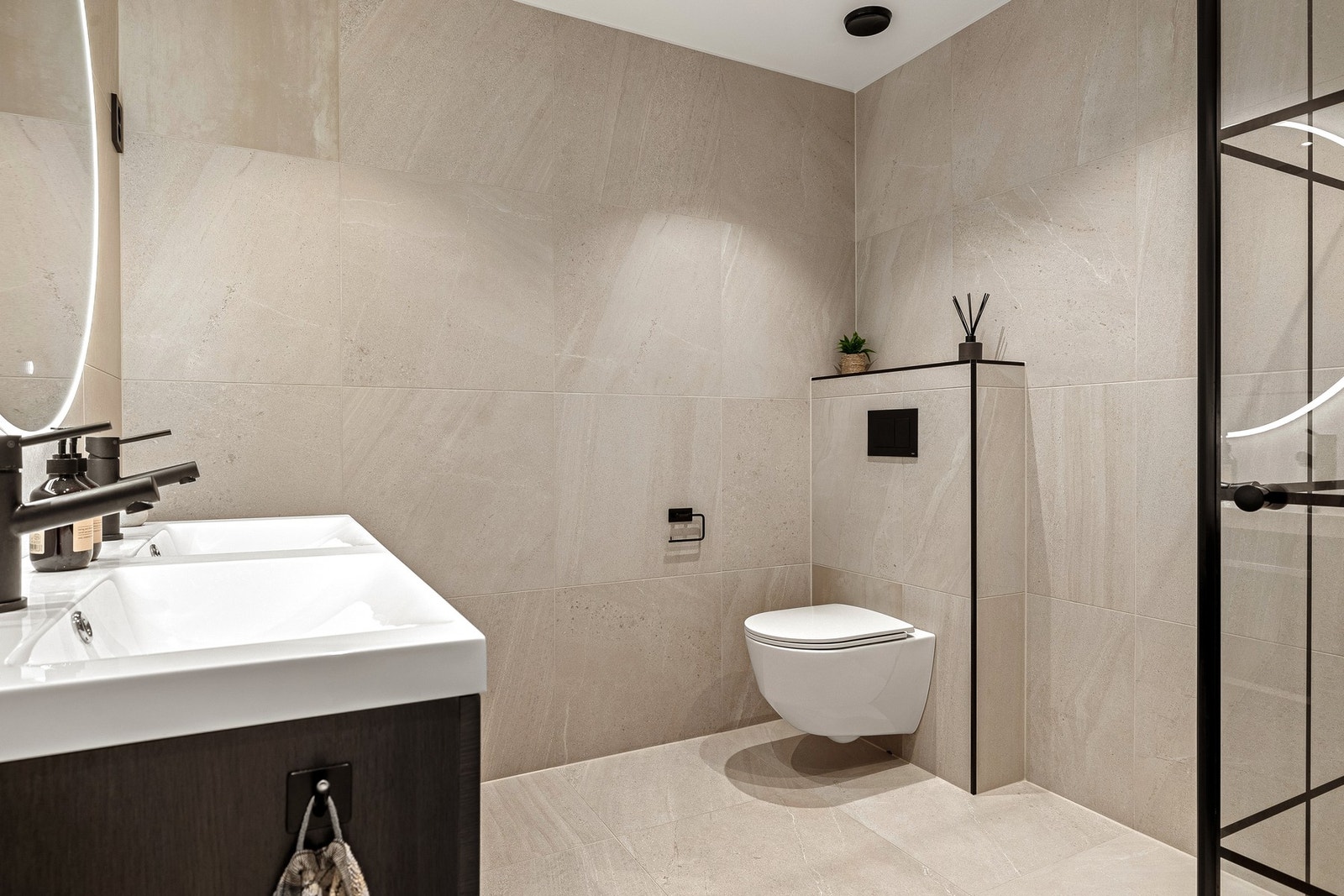 Badet er helfliset i lyse moderne fliser med downlights i himling og behagelige varmekabler i gulv. Galleribilde