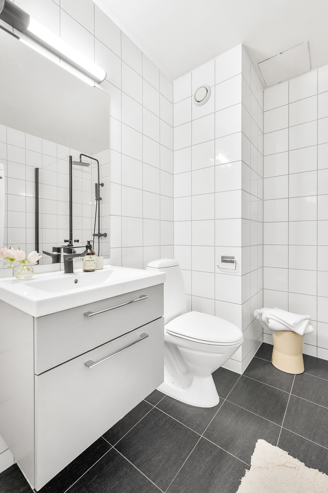 Pent flislagt bad med elektriske varmekabler i gulv. Det ble lagt nye fliser på gulvet, byttet dusjdører og blandebatteri for vask og dusj i 2022. Galleribilde