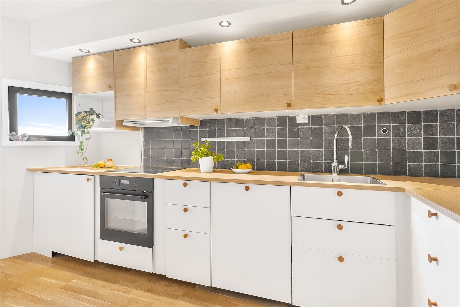 Kjøkkeninnredningen er fra IKEA og har slette lakkerte fronter nede, og finerte fronter på overskapene. Induksjonsplatetopp, stekeovn, oppvaskmaskin og kjøl/fryseskap er integrert. Galleribilde