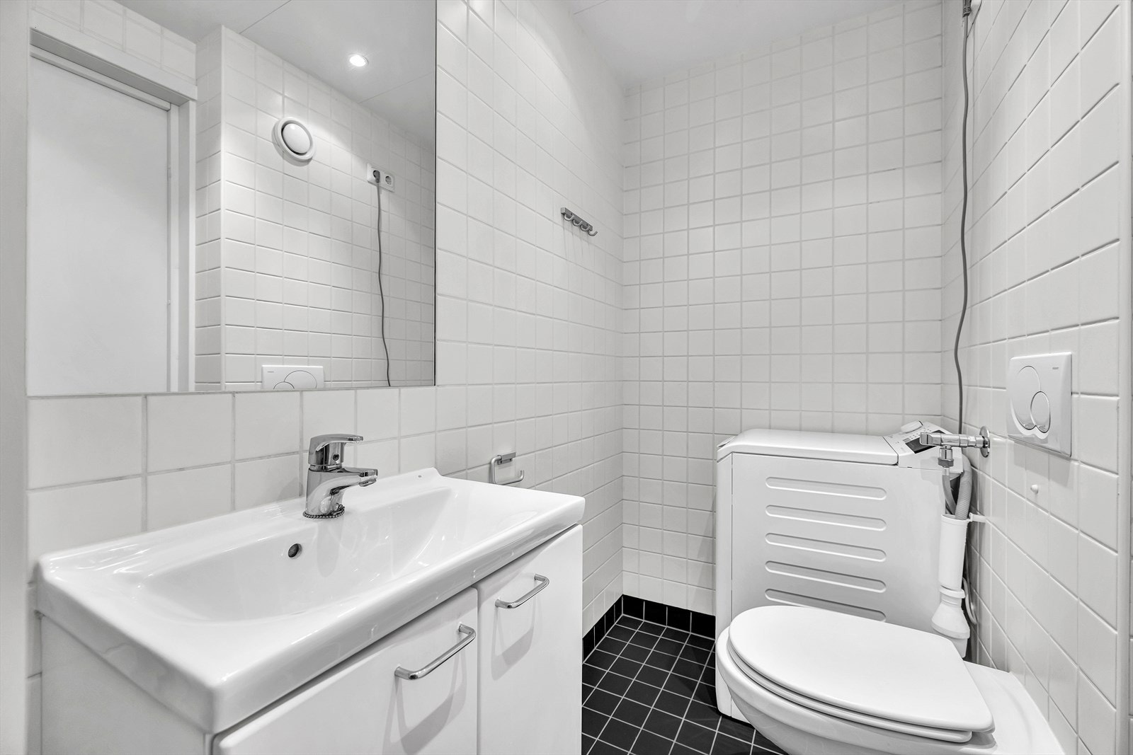 Romslig flislagt baderom fra byggeåret 2007. Her er det vegghengt klosett, opplegg for vaskemaskin/tørketrommel samt servant med underskap Galleribilde