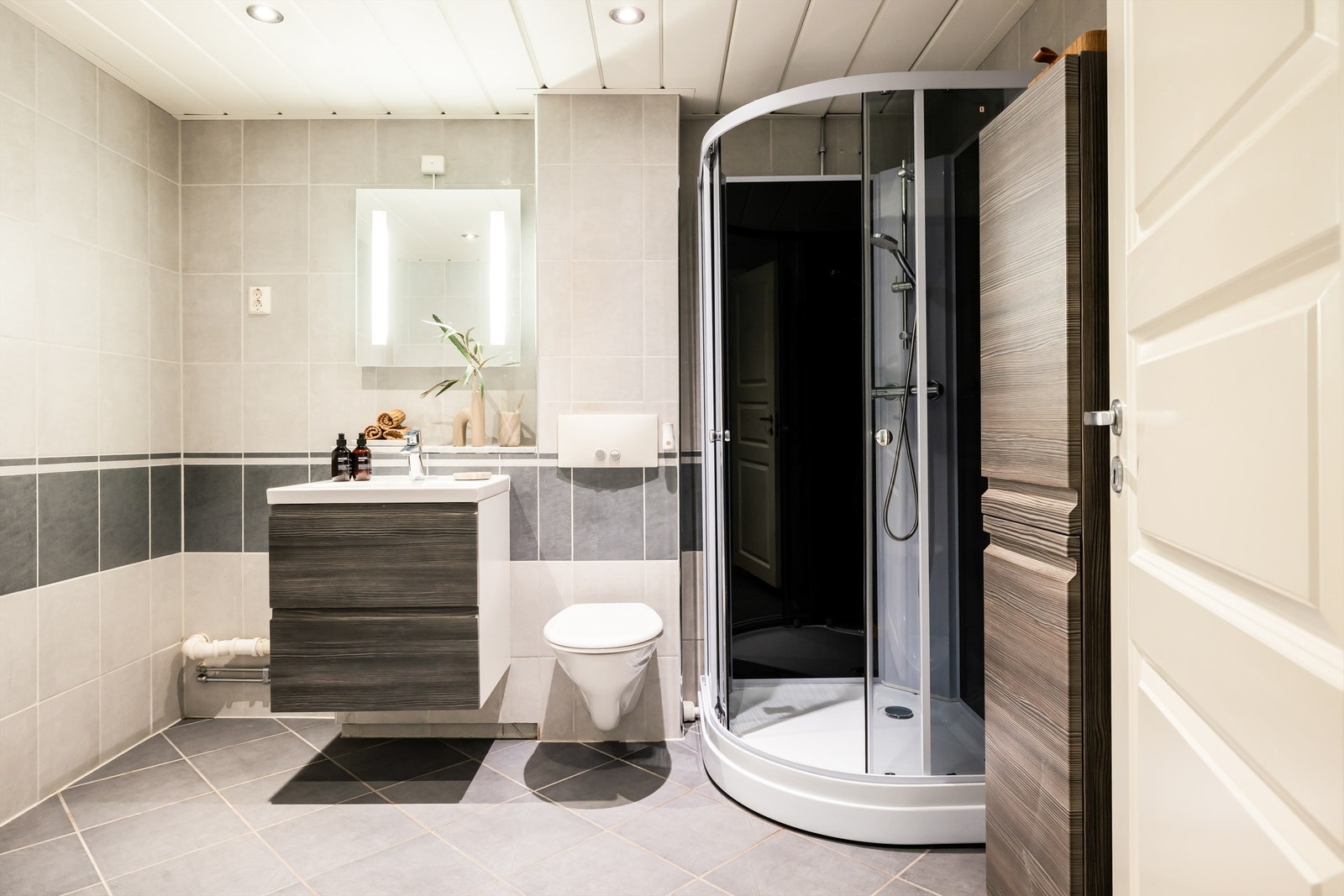 Flislagte vegger og gulv. Ved siden av servanten er det opplegg for vaskemaskin. Galleribilde