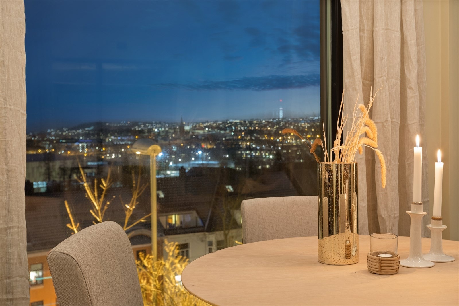 Kveldsbilde med nydelig utsikt over byen. Boligen ligger godt til i høyden, og har dermed begrenset med innsyn for forbipasserende trafikk. Galleribilde