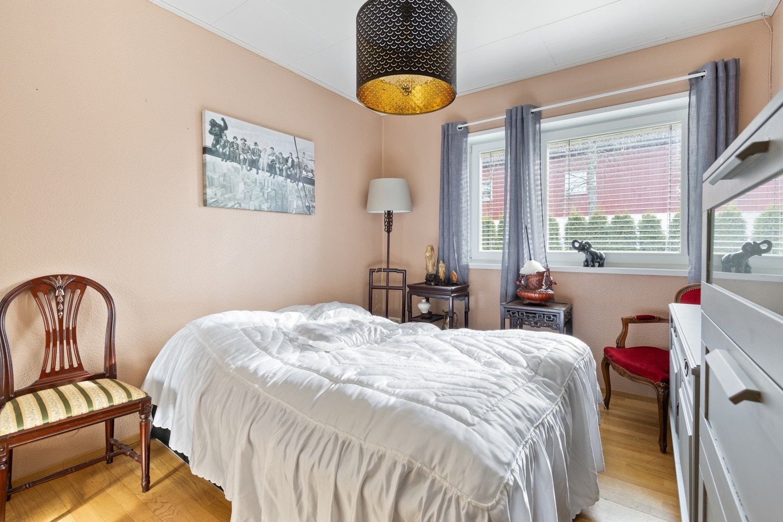 Soverom 2 fremstår som et koselig soverom med lyse veggflater, parkett på gulv og et stort vindu. Galleribilde