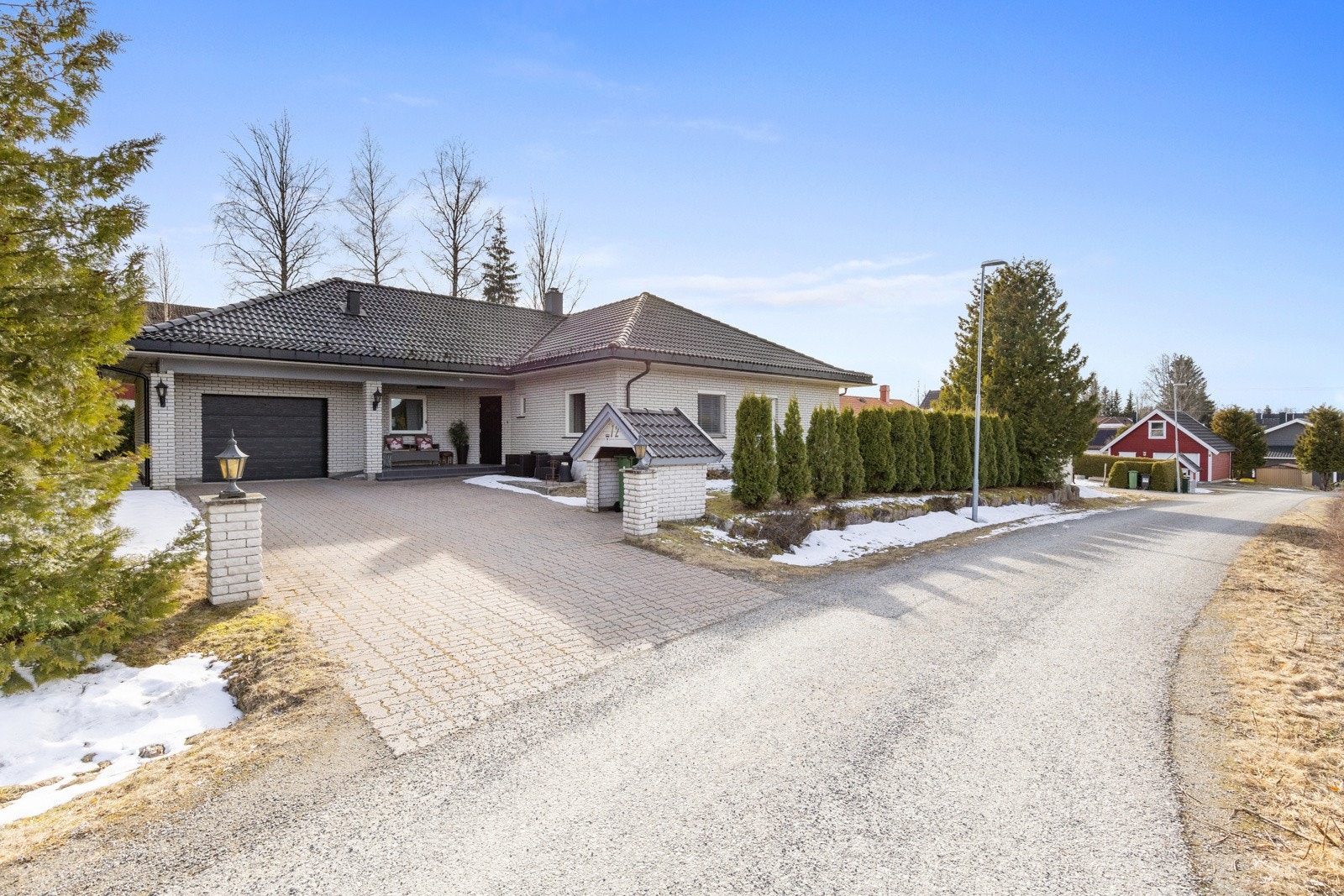 Det er satt opp støttemur, samt hekk mot vei. Gårdsplassen er belagt med belegningsstein. Galleribilde