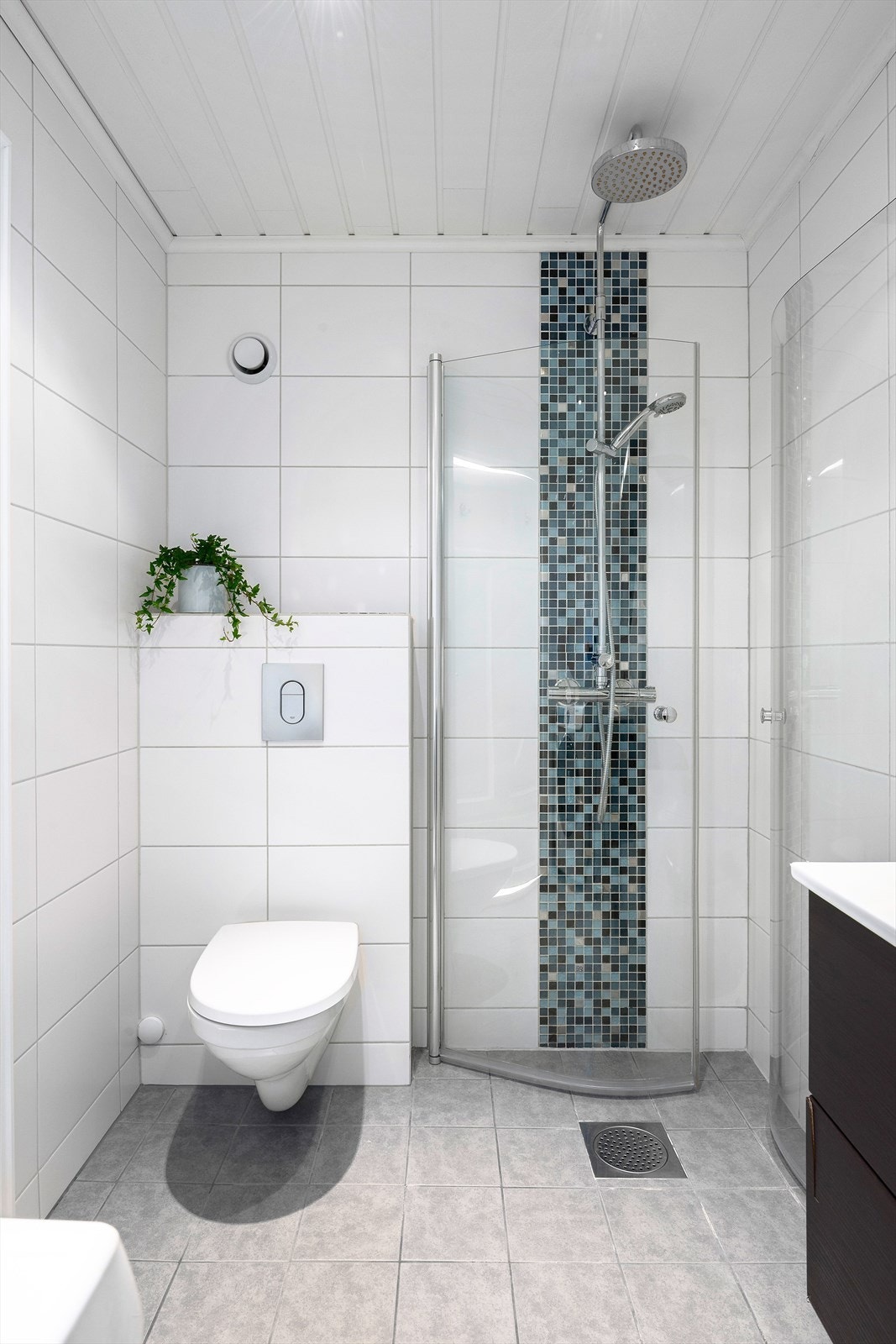 Pent flislagt bad fra 2012 med blant annet varmekabler i gulv, toalett og praktisk dusjhjørne med innfellbare dusjdører. Galleribilde