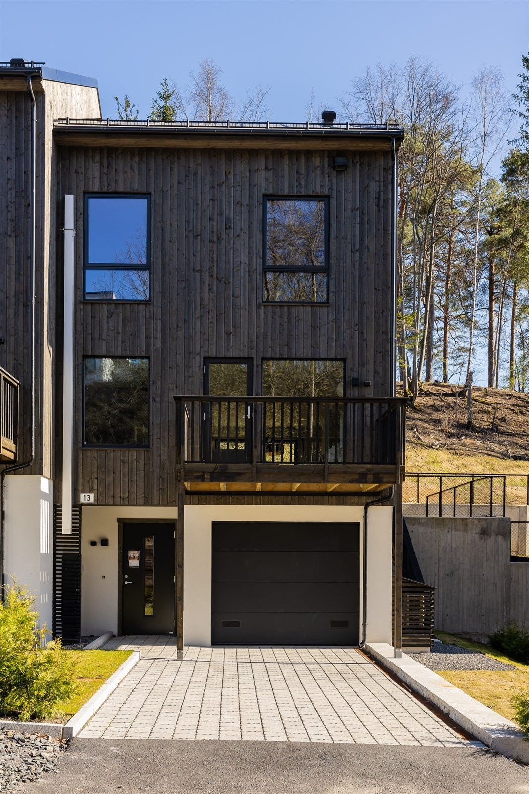 Fasade Ravnsborgdelet 13. Utenfor garasjen har man plass til enda en bil. Galleribilde