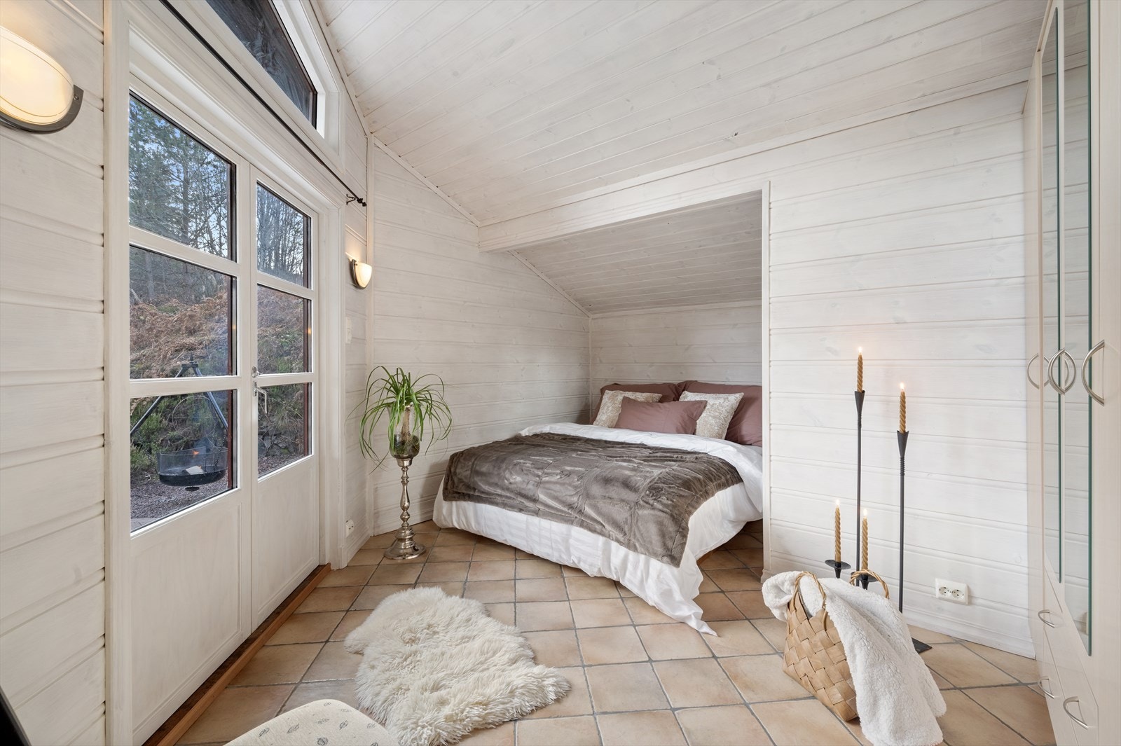 Romslig hovedsoverom med adgang ut på stor markterrasse via doble balkongdører. Galleribilde