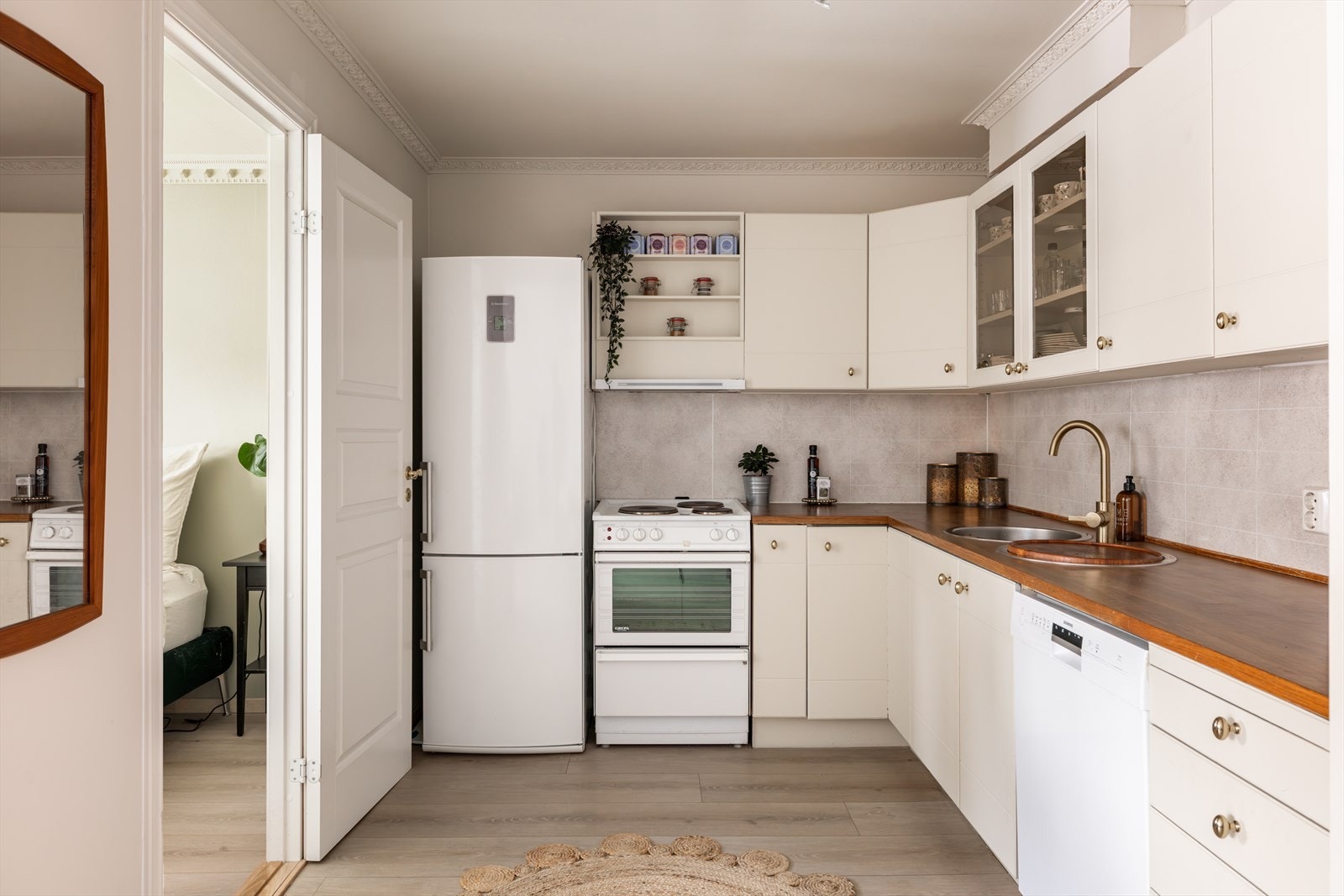 Det er frittstående hvitevarer med komfyr og kjøleskap, samt oppvaskmaskin plassert i nisje under benkeplaten. Galleribilde