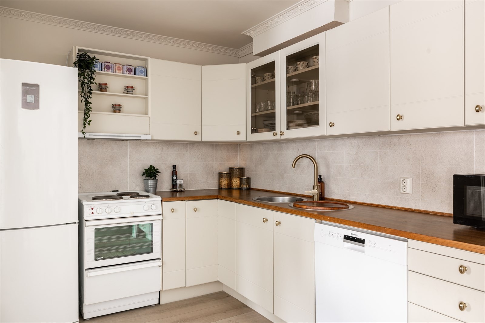 Mellom benkeplate og overskap er det montert veggplater som etterligner fliser, i en farge som står i stil til resten av kjøkkenet. Galleribilde