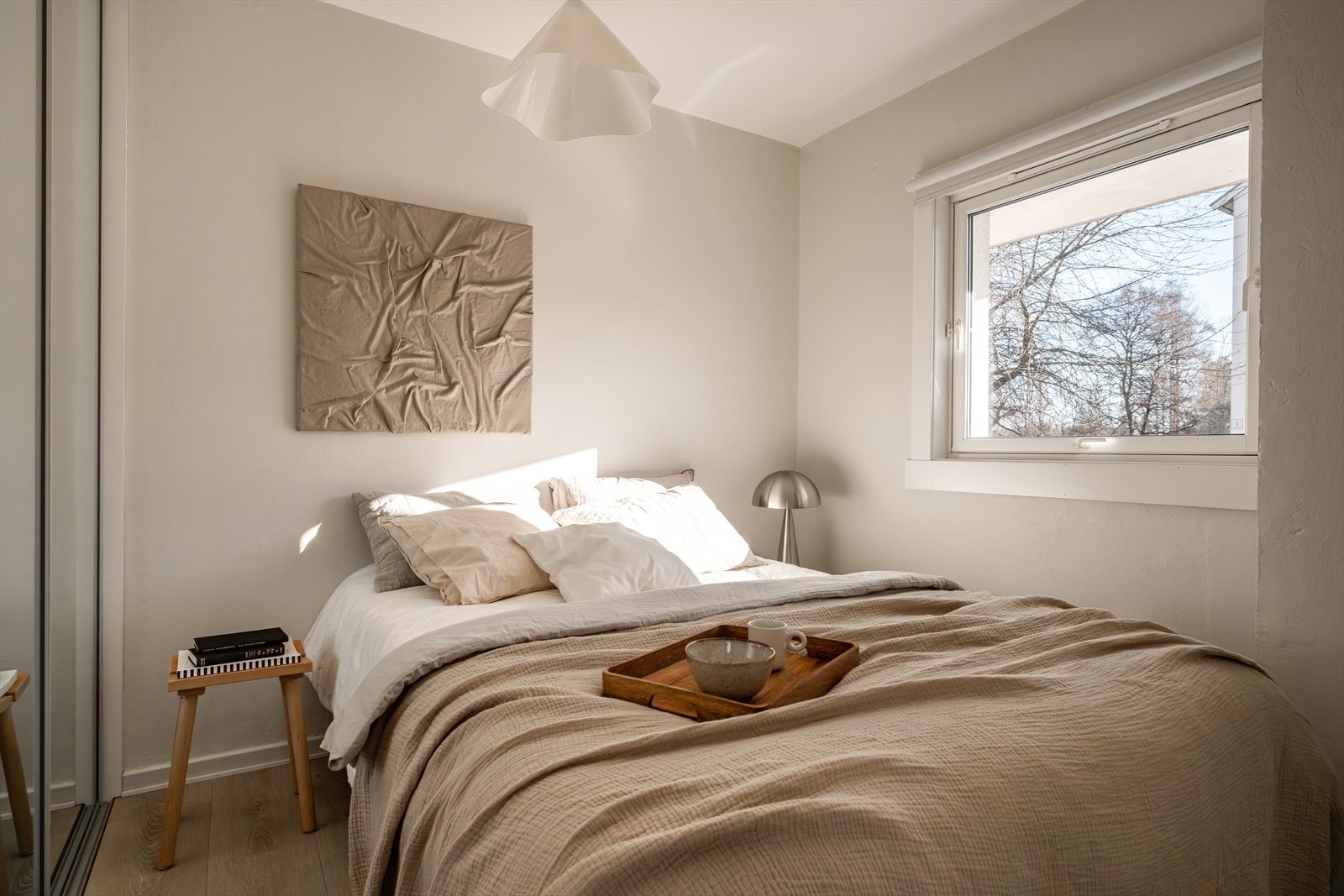 Koselig og lunt soverom med plass til dobbeltseng, nattbord og dyp skyvedørsgarderobe med speilfronter. Stort vindu som vender mot rolig uteområde. Galleribilde