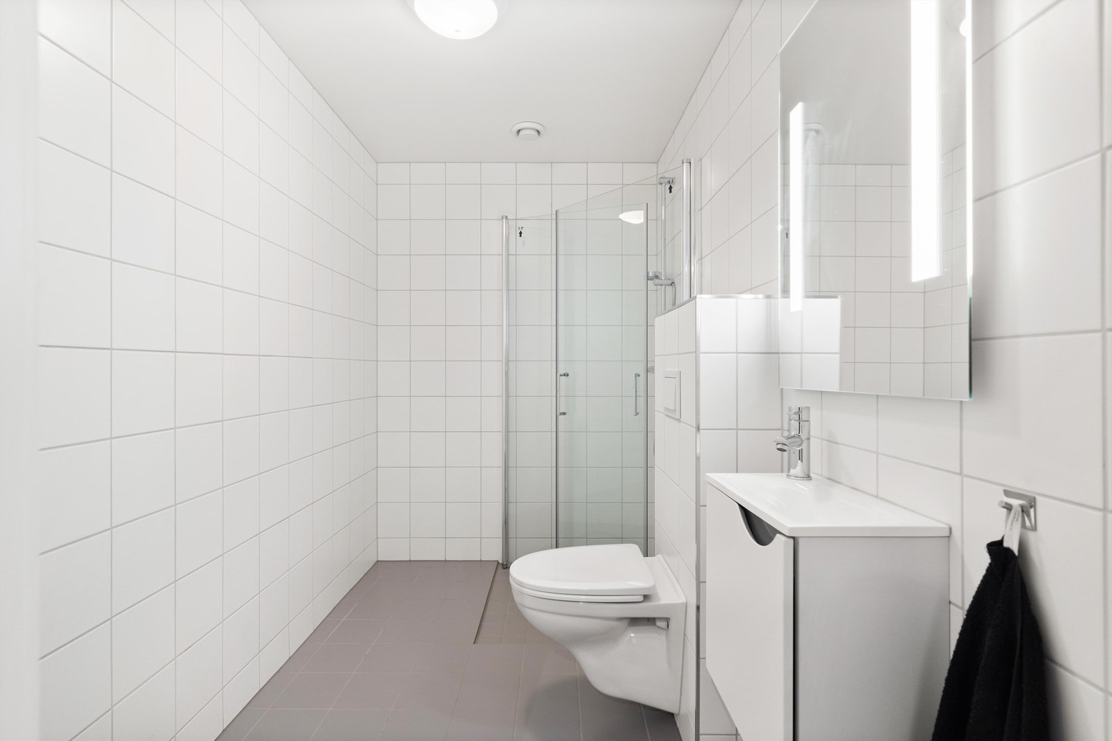 Det andre badet fremstår som et flott gjestebad. Her er det enkeltservant, dusjhjørne med innfellbare glassdører og vegghengt toalett. Galleribilde