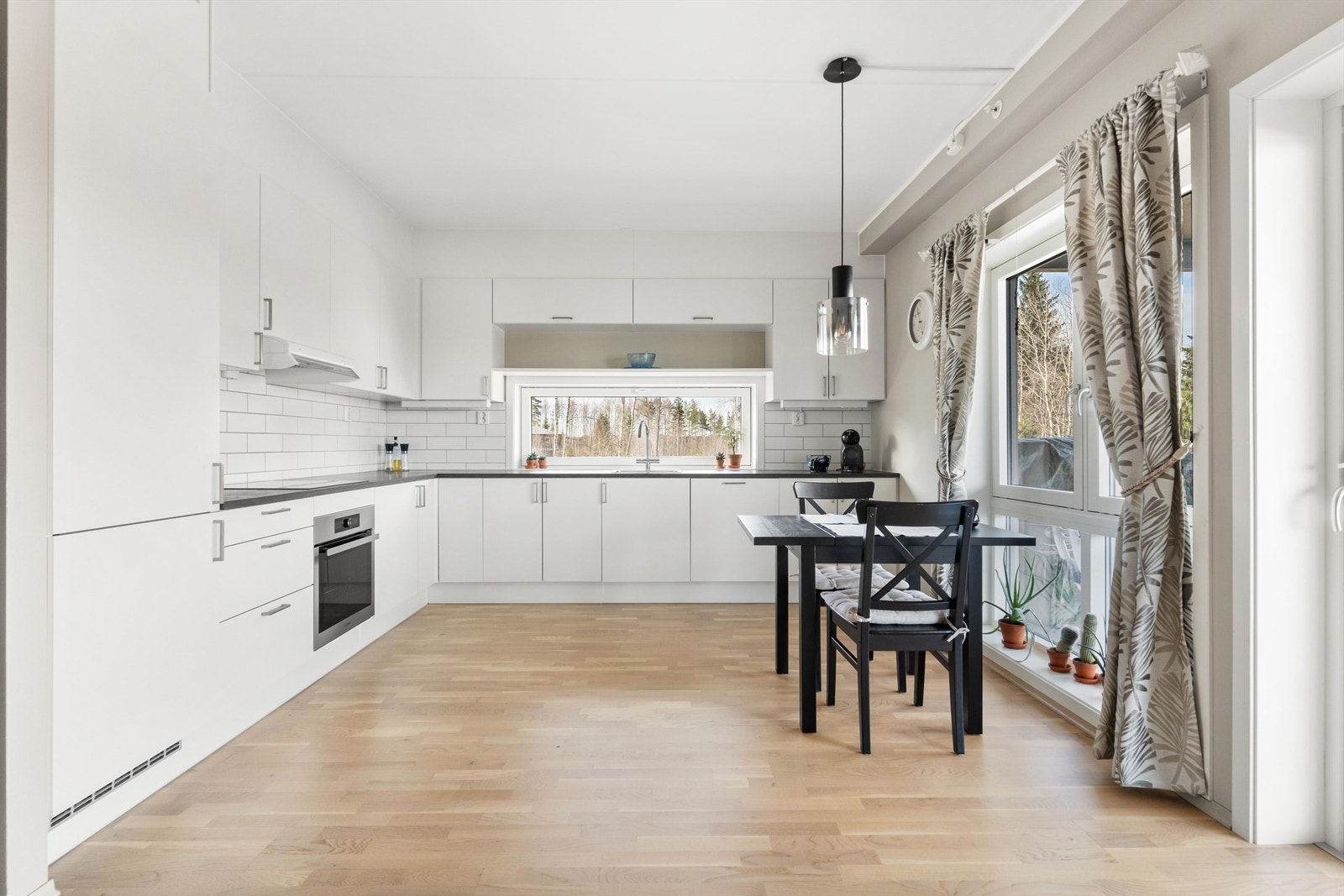 Tidløs og innbydende HTH- kjøkkeninnredning med hvite, glatte fronter. Galleribilde