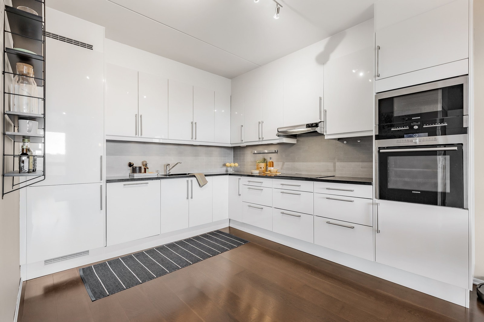 Lyst og moderne kjøkken med integrerte hvitevarer. Galleribilde